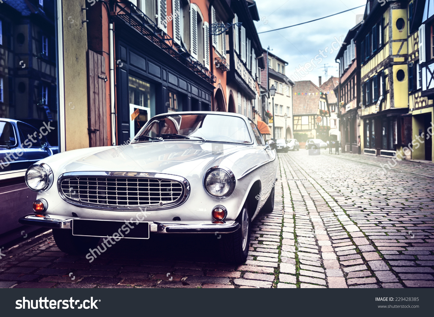 レトロな車がヨーロッパの古い街並みに停められている の写真素材 今すぐ編集
