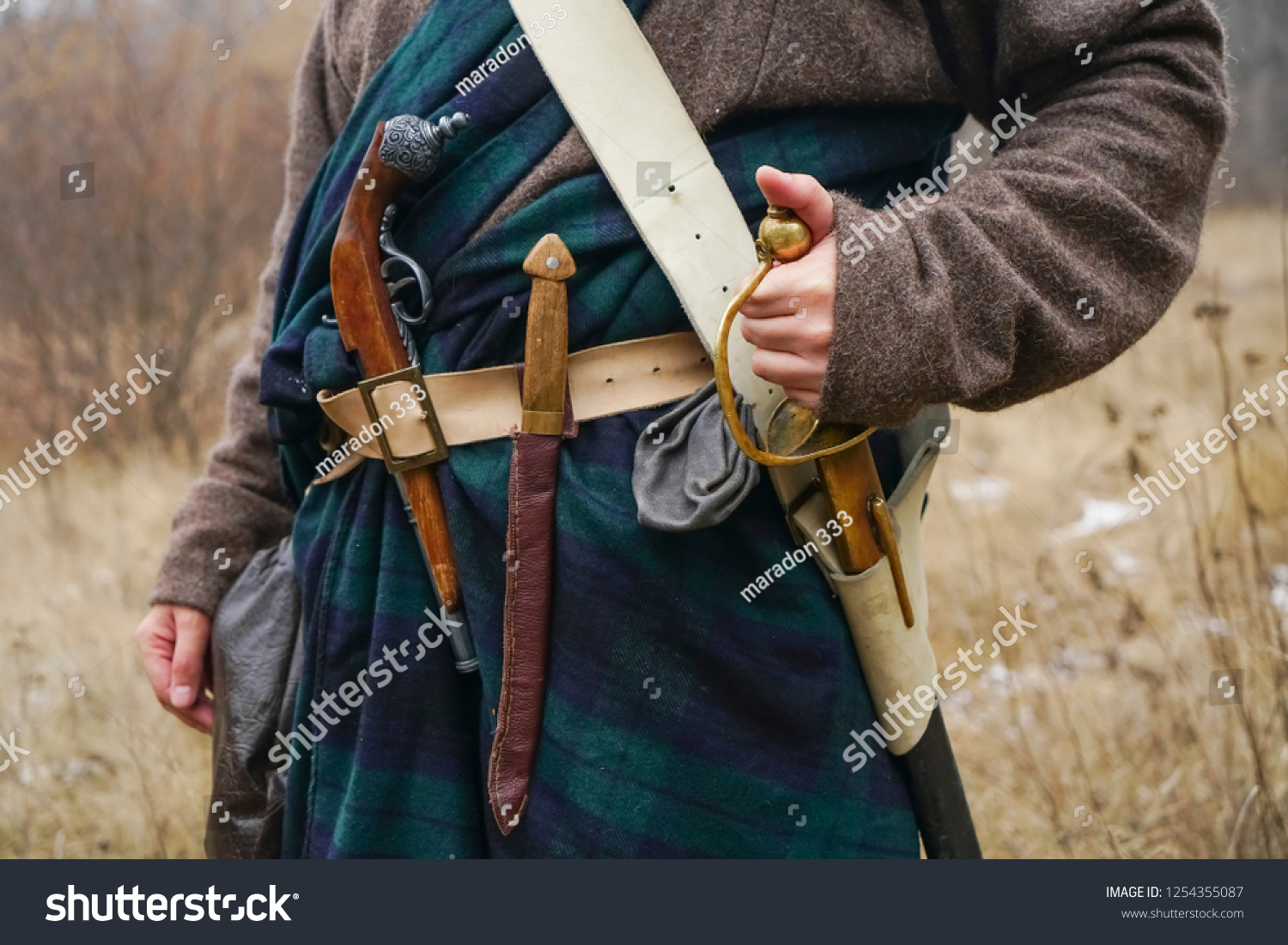 レトロな古いサーベル ナイフ 古い銃がスコットランドの岬の帯にぶら下がっている の写真素材 今すぐ編集