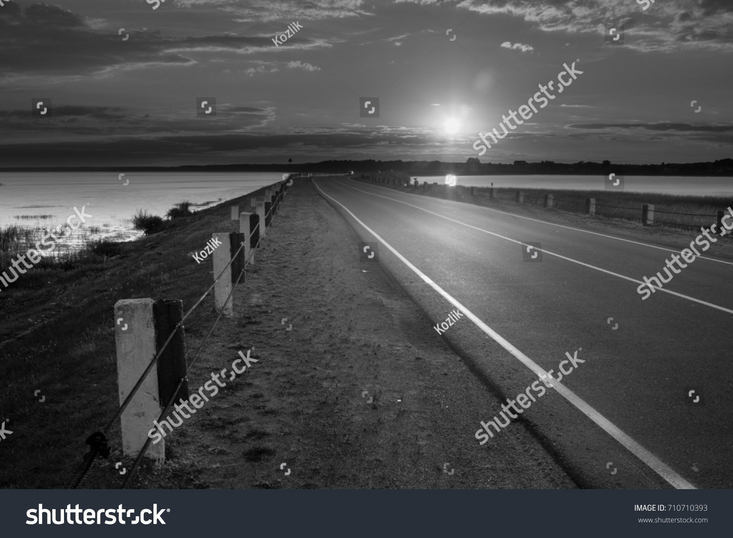 Road with beautiful scenery lake and sky black and white photo