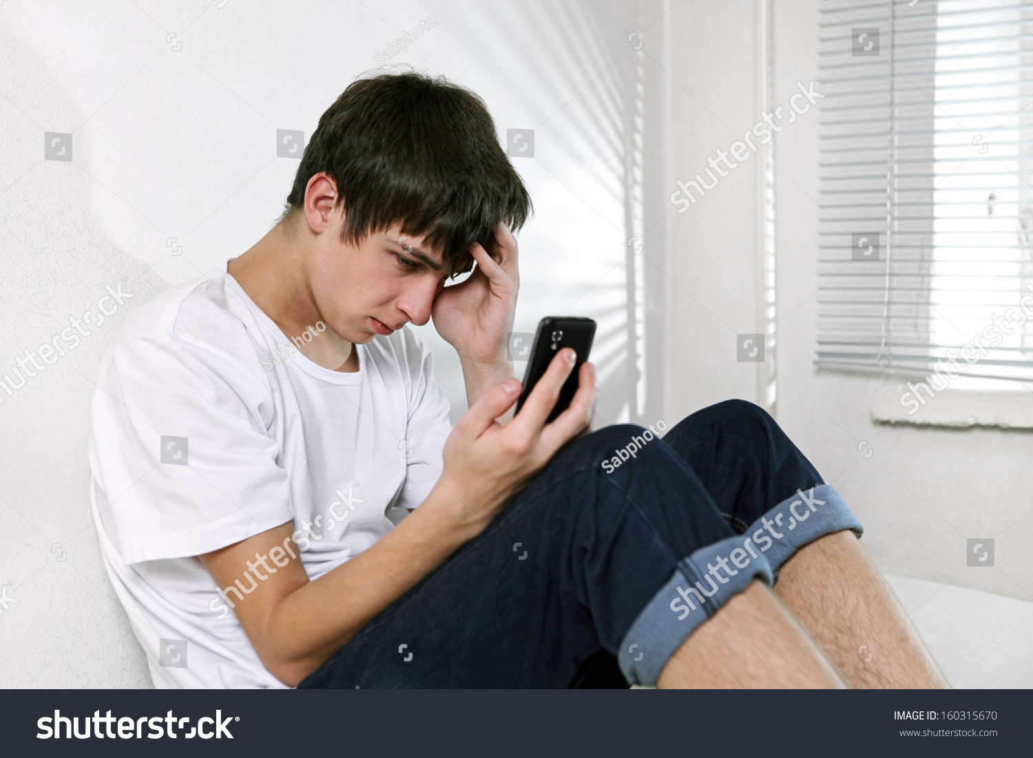 stock-photo-sad-young-man-with-cellphone
