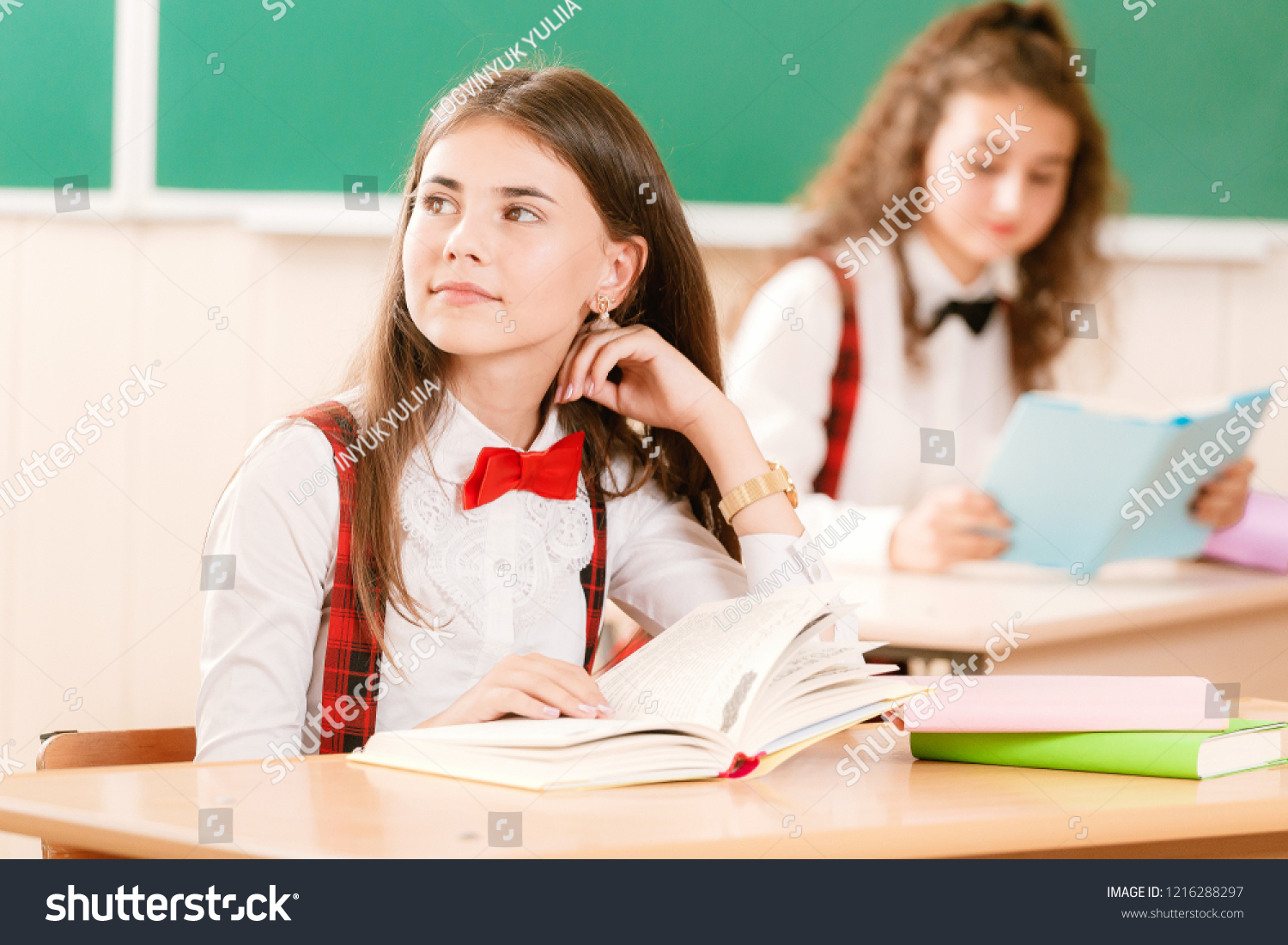 Schoolgirls In School Uniforms Sit For Couples In The Classroom Girls