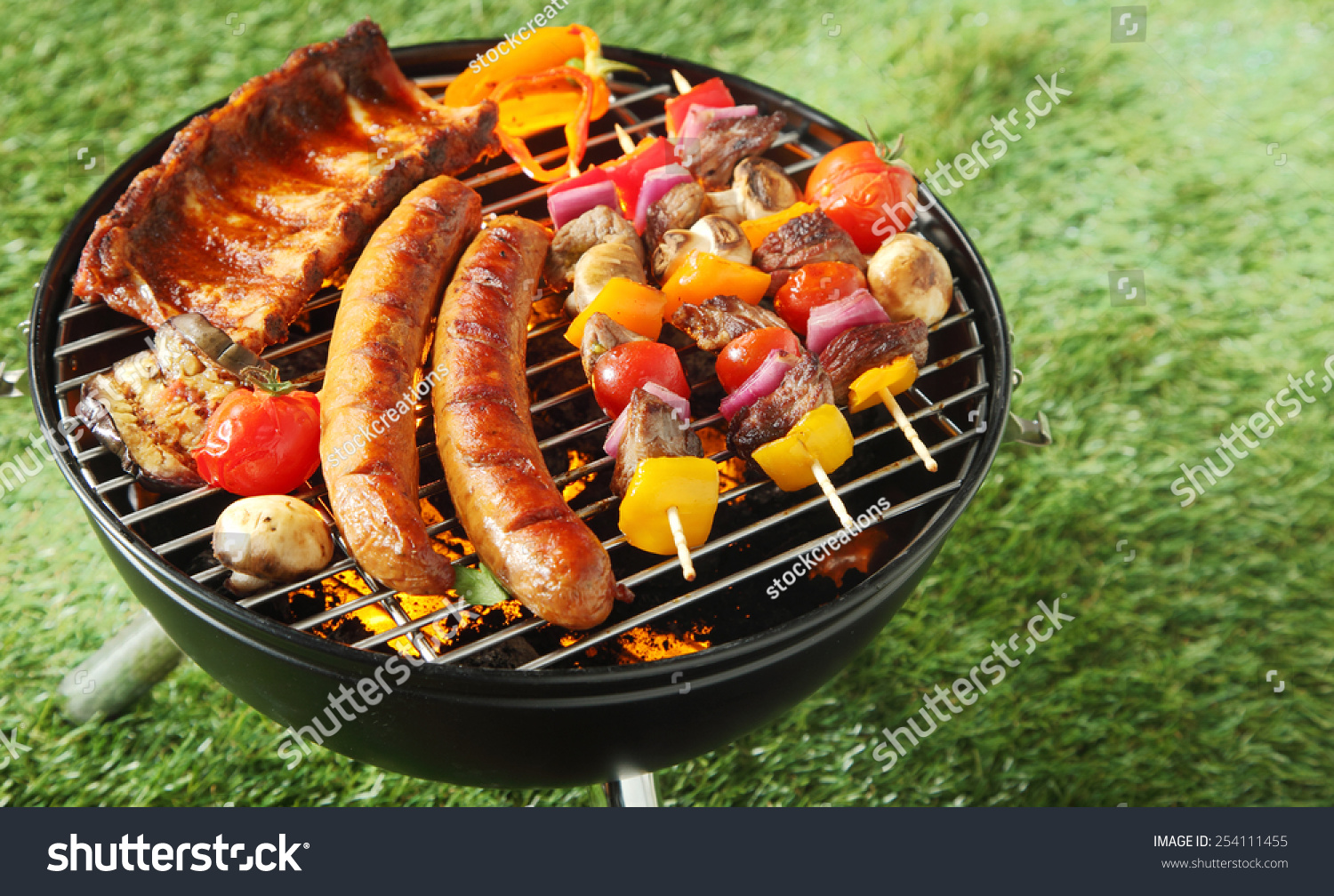 Selection Of Meat Grilling Over The Coals On A Portable Barbecue With ...