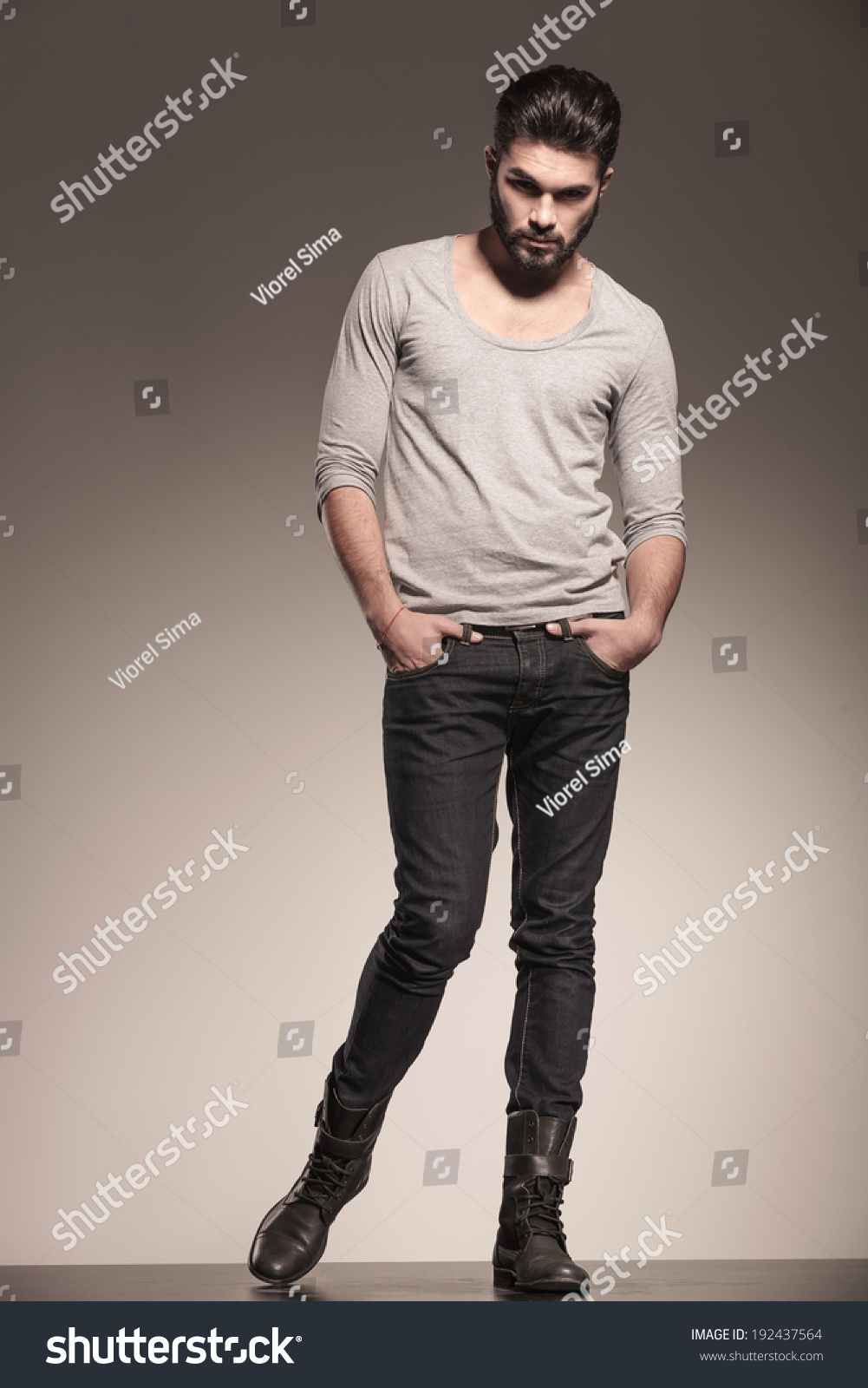 Serious Fashion Model Posing With Hands In His Pockets In Studio Stock ...