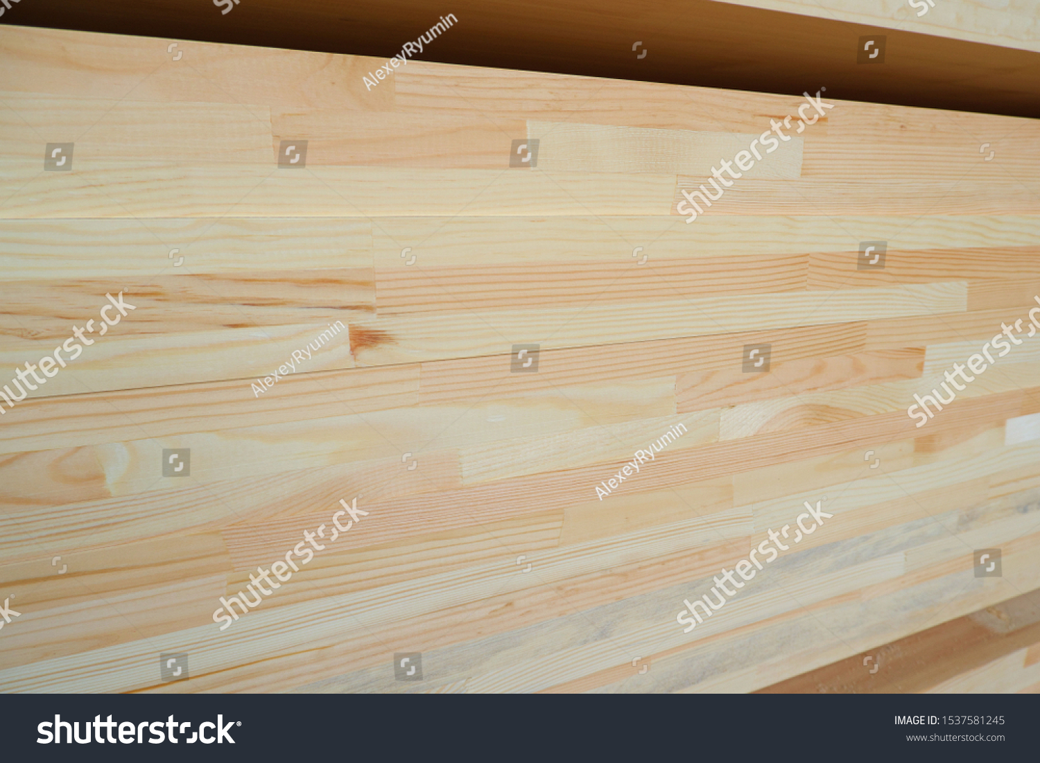 Side view of stack of three-layer wooden glued laminated timber beams from pine finger joint spliced boards for wooden windows