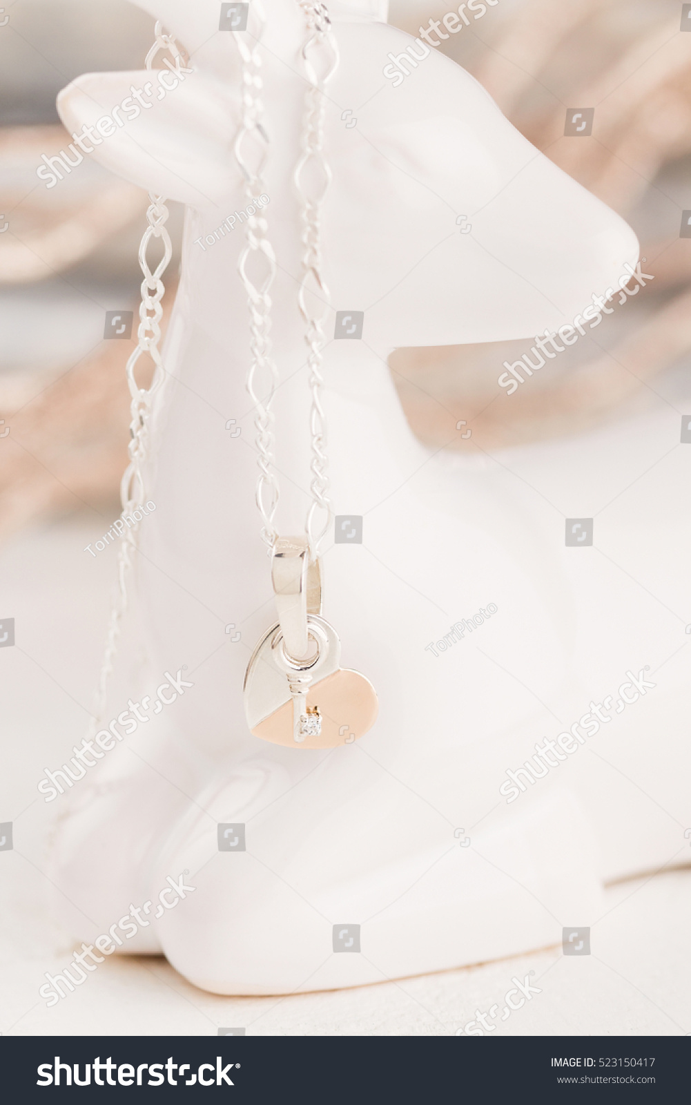 https://www.shutterstock.com/pic-523150417/stock-photo-silver-and-gold-heart-shaped-with-key-pendant-necklace.html