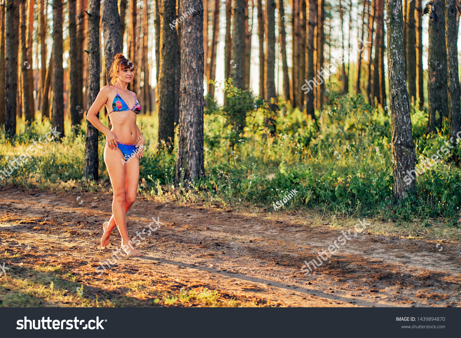 https://image.shutterstock.com/z/stock-photo-slender-woman-barefoot-in-a-bikini-on-nature-at-sunset-1439894870.jpg