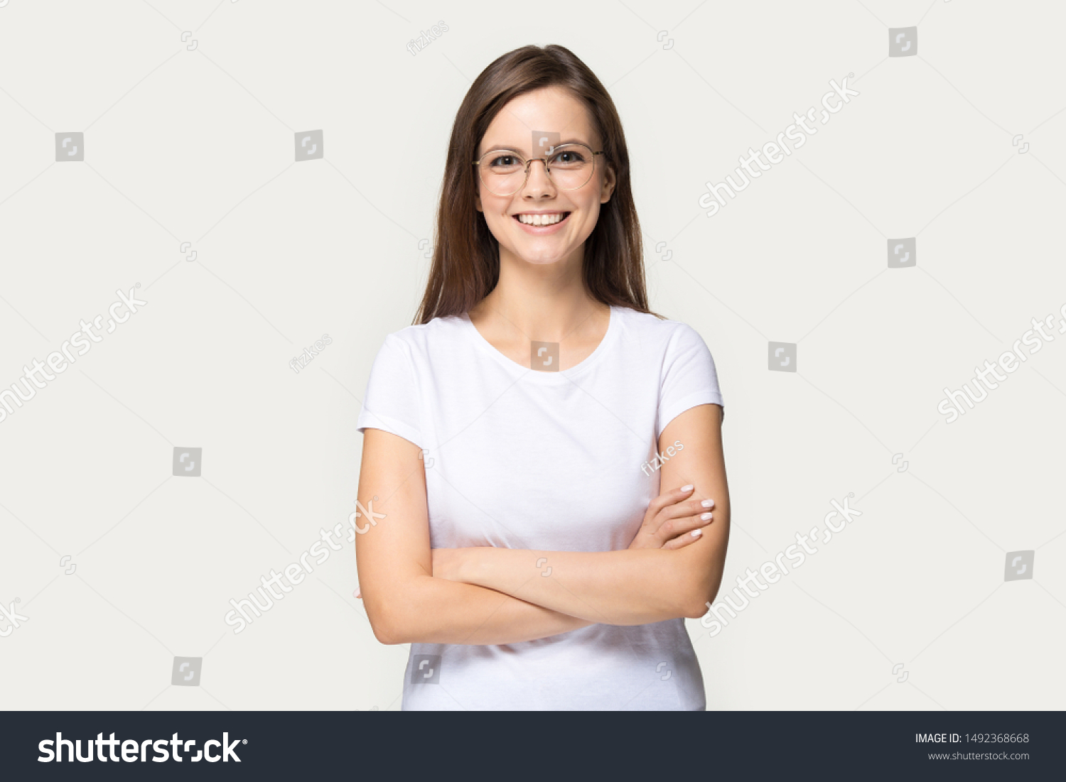 1 810 Im Genes De Body Language Crossed Arms Im Genes Fotos Y   Stock Photo Smiling Beautiful Millennial Girl Wear Glasses And White T Shirt Stand With Arms Crossed Isolated 1492368668 