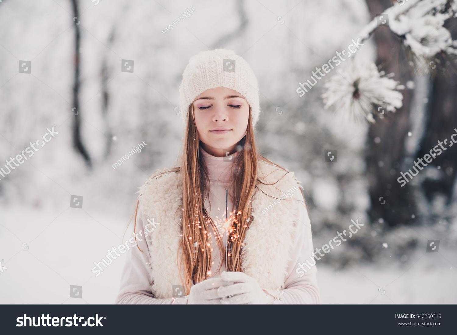 Smiling Teen Girl 14 16 Year Old Wearing Winter Knitted Clothes Holding Sparkler Outdoors Over Smiling Teen Girl 14 16 Year Old Wearing Winter Knitted Clothes Holding Sparkler Outdoors Over