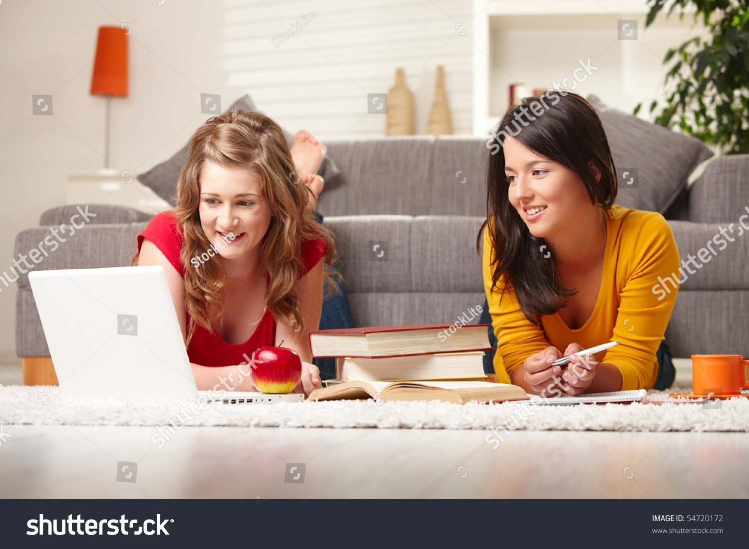 Smiling Teen Girls Sitting On Floor Of Living Room Smiling Looking At ...