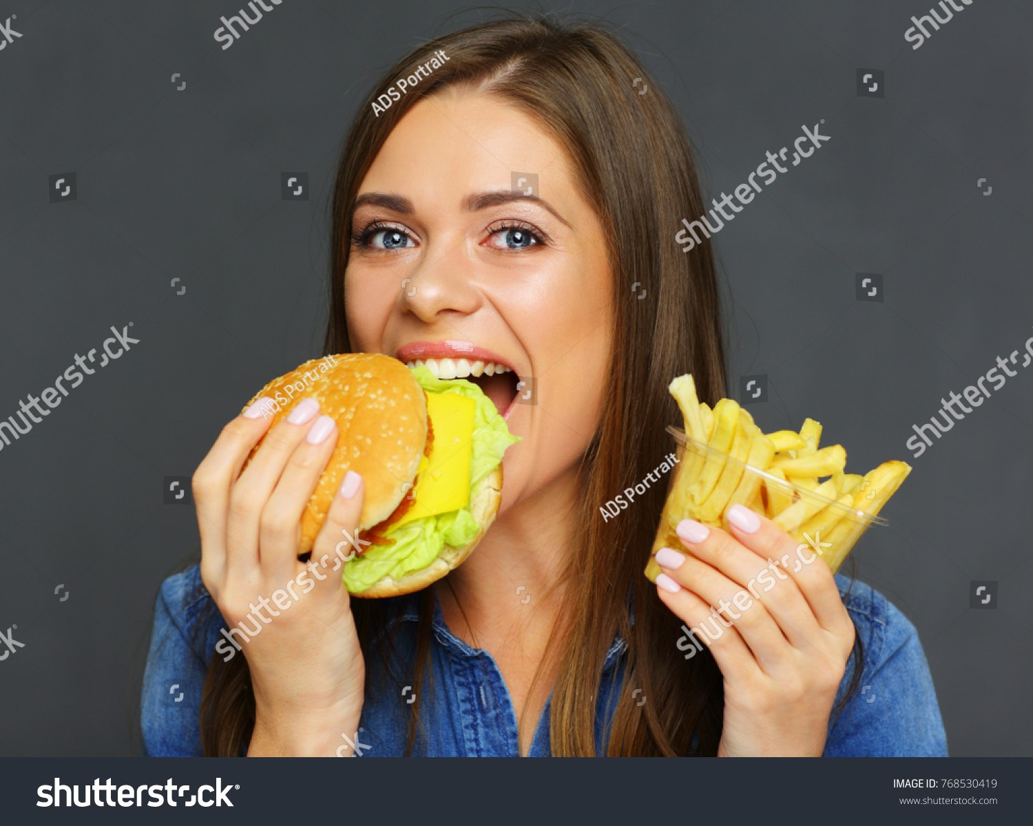 Smiling Woman Biting Burger Holding French Stock Photo (Edit Now) 768530419