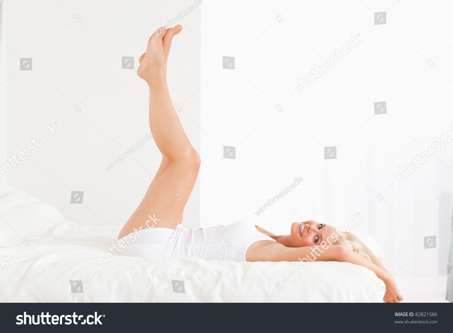 Smiling Woman With The Legs Up While Lying On Her Bed Stock Photo ...