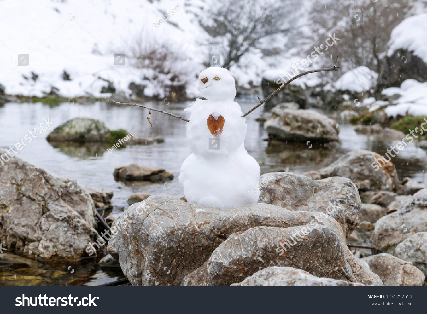 Snowman Standing On Rock Near River Stock Photo Edit Now