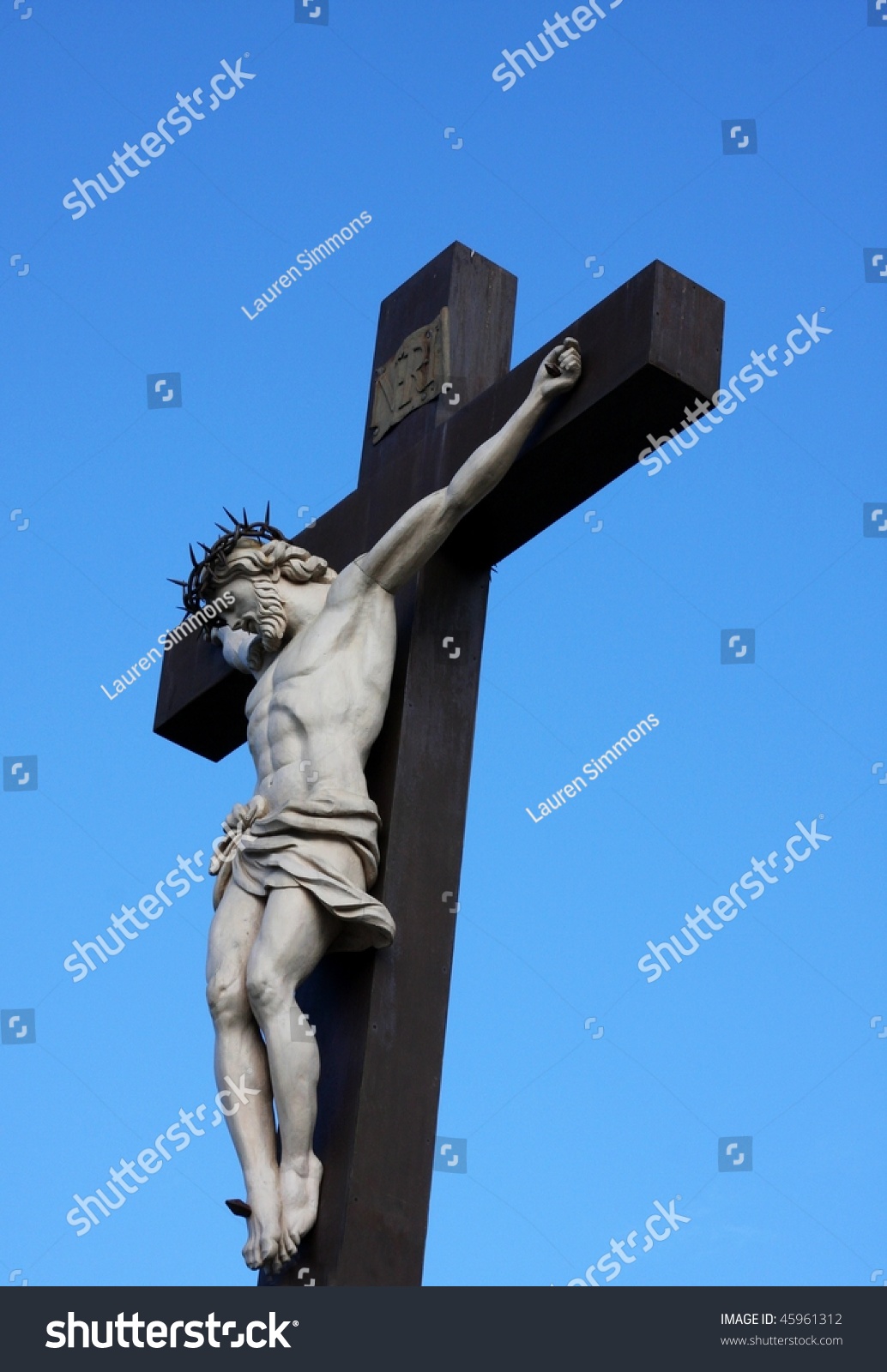 Statue Of Jesus Christ Hanging On Wooden Cross Against Blue Sky ...