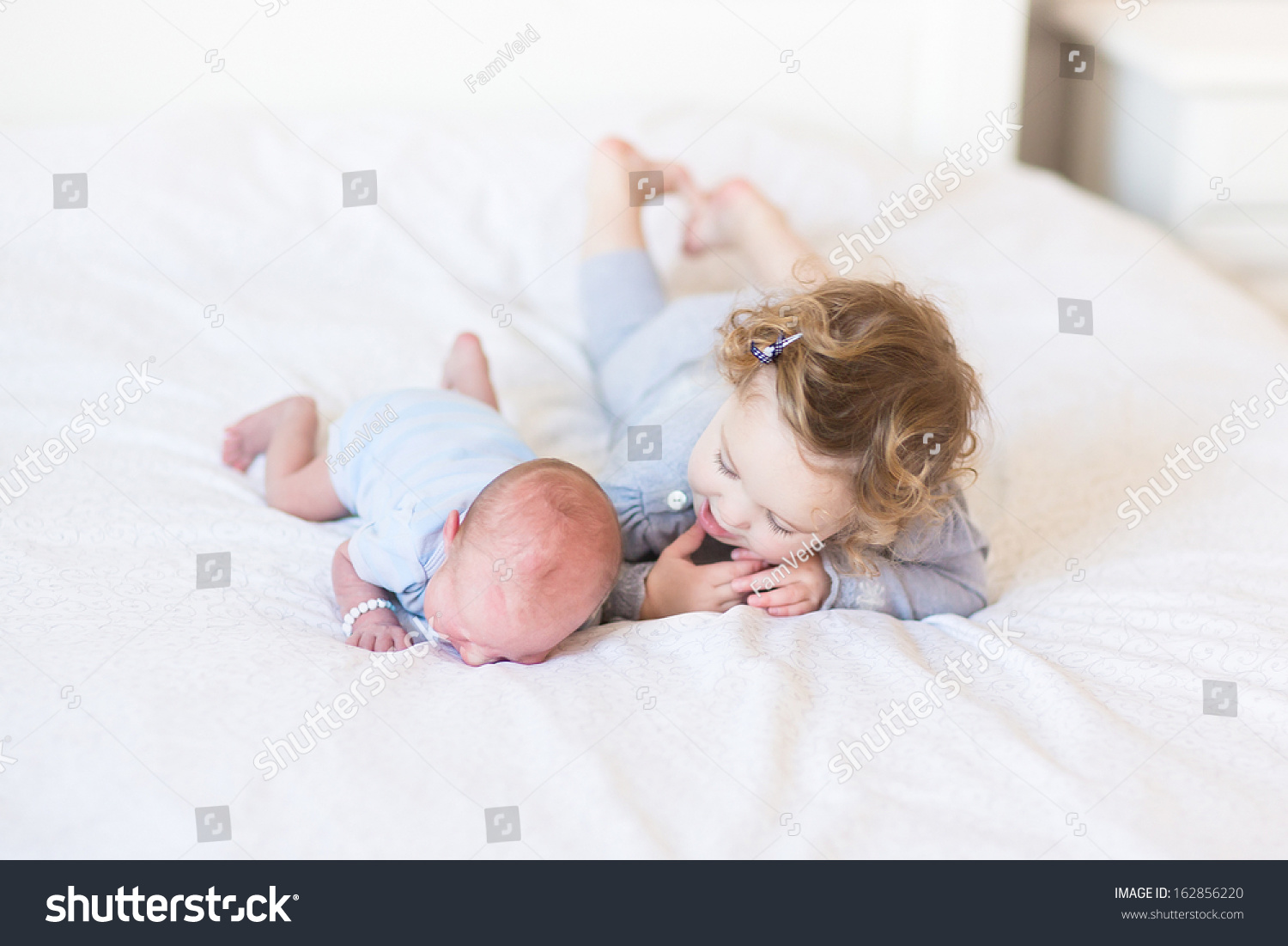 Sweet Toddler Girl Supporting Her Newborn Baby Brother Laying On His ...