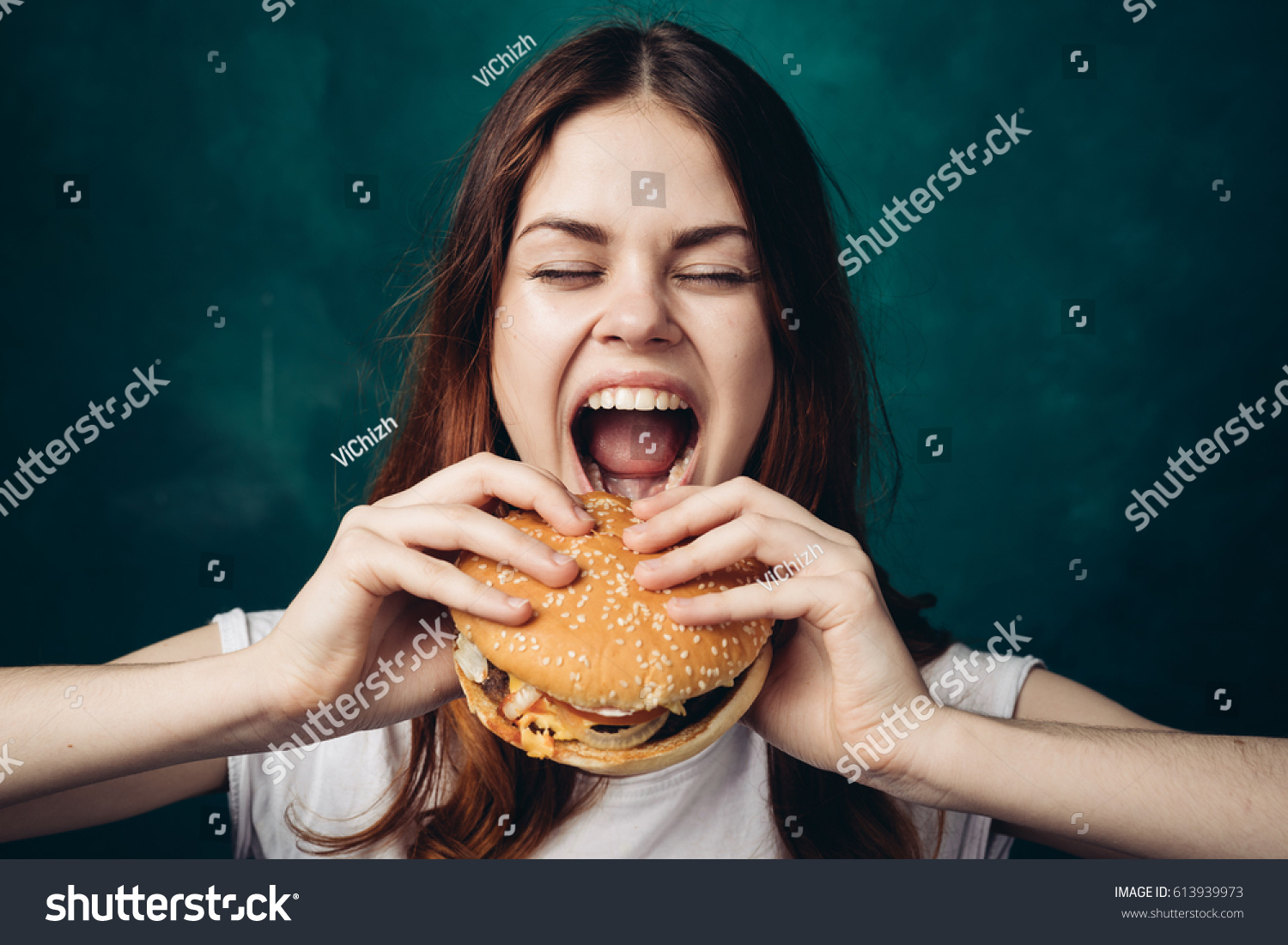 その女性は口を開いてハンバーガーを食べ 手にハンバーガーを ハンバーガーを持つ女性を食べた の写真素材 今すぐ編集