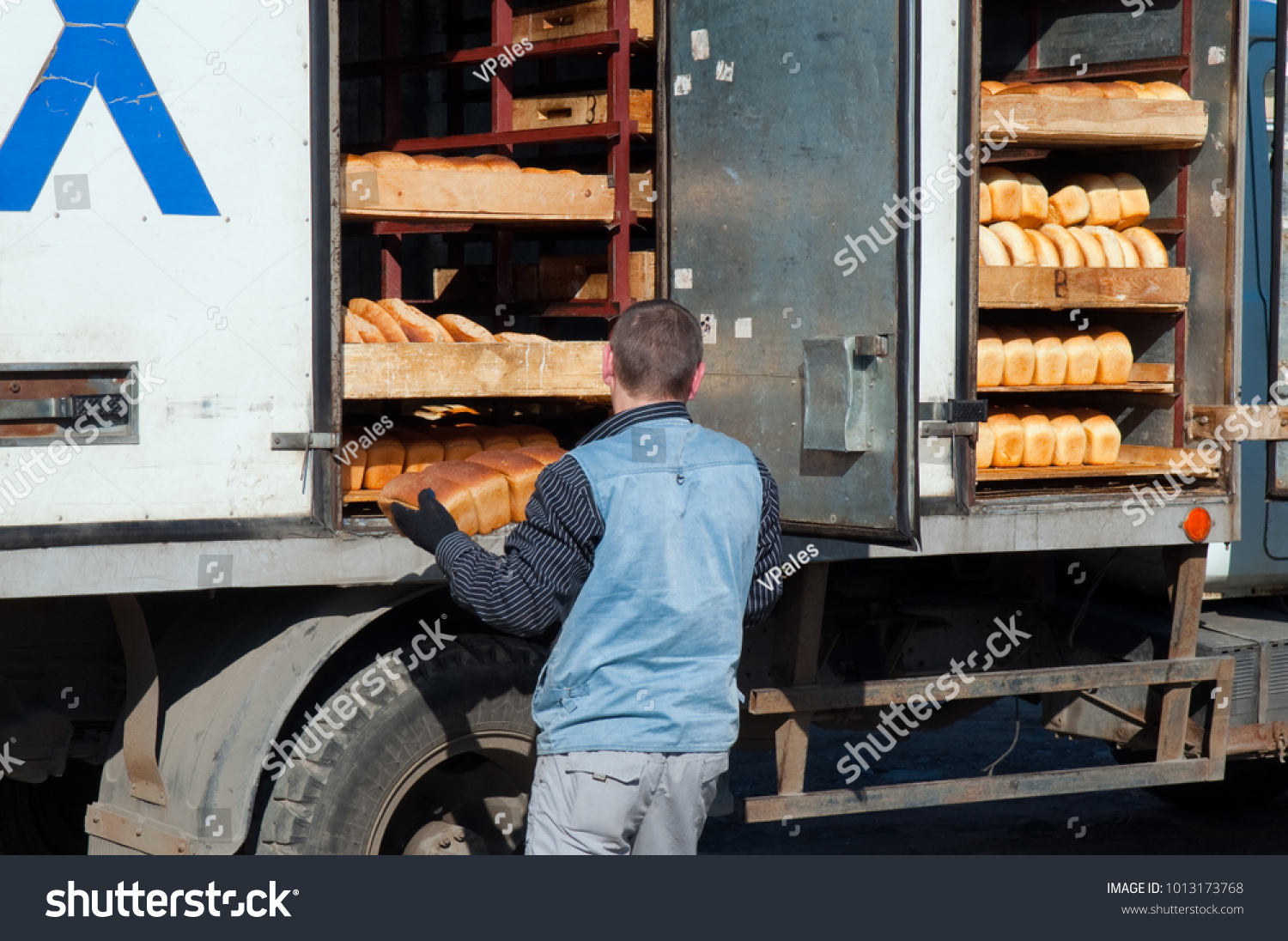 Stock Photo The Worker Unloads Fresh Bread From The Truck 1013173768 