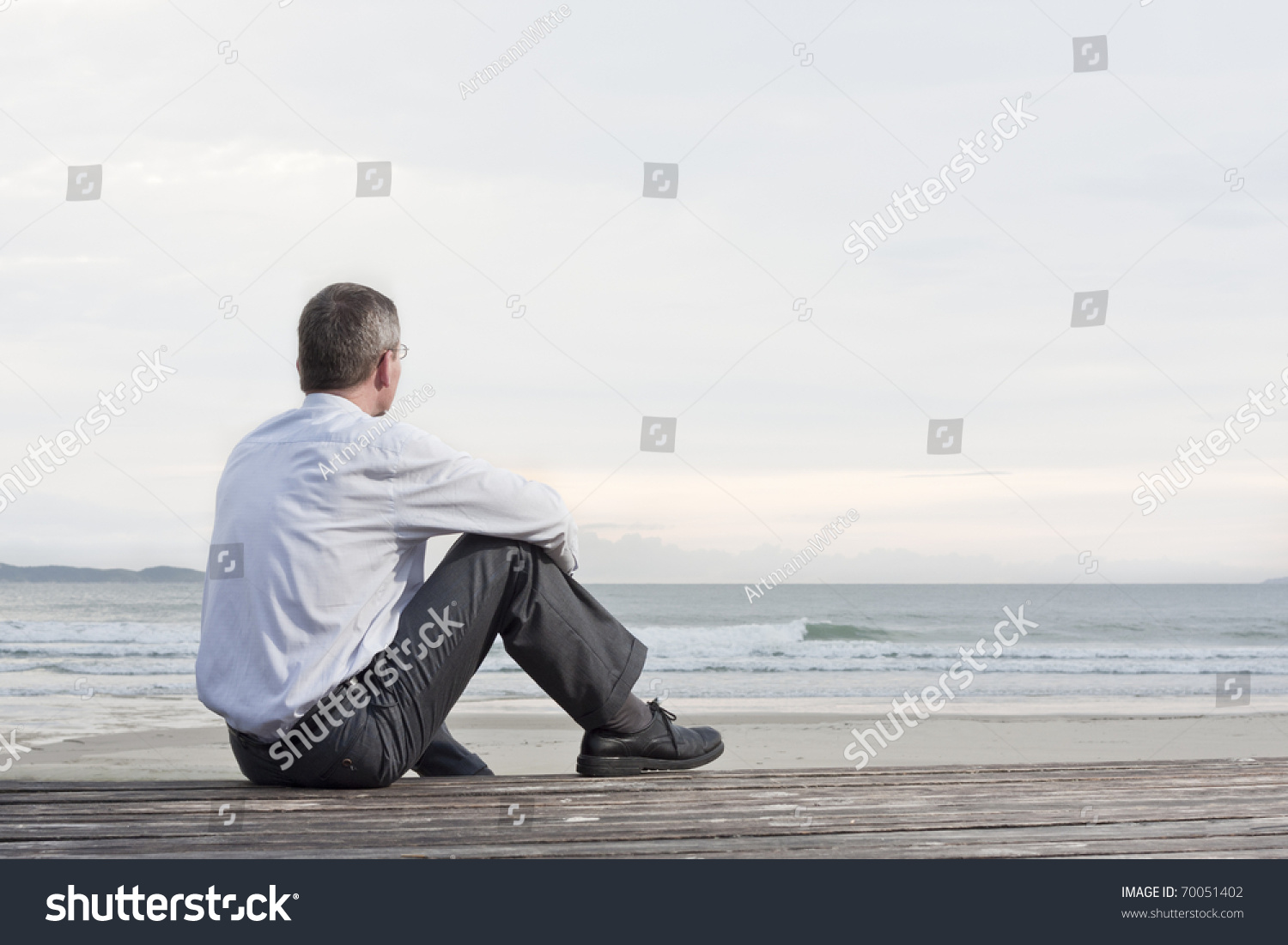 Thoughtful Businessman Sitting On A Beach And Looking At The Sea Stock ...