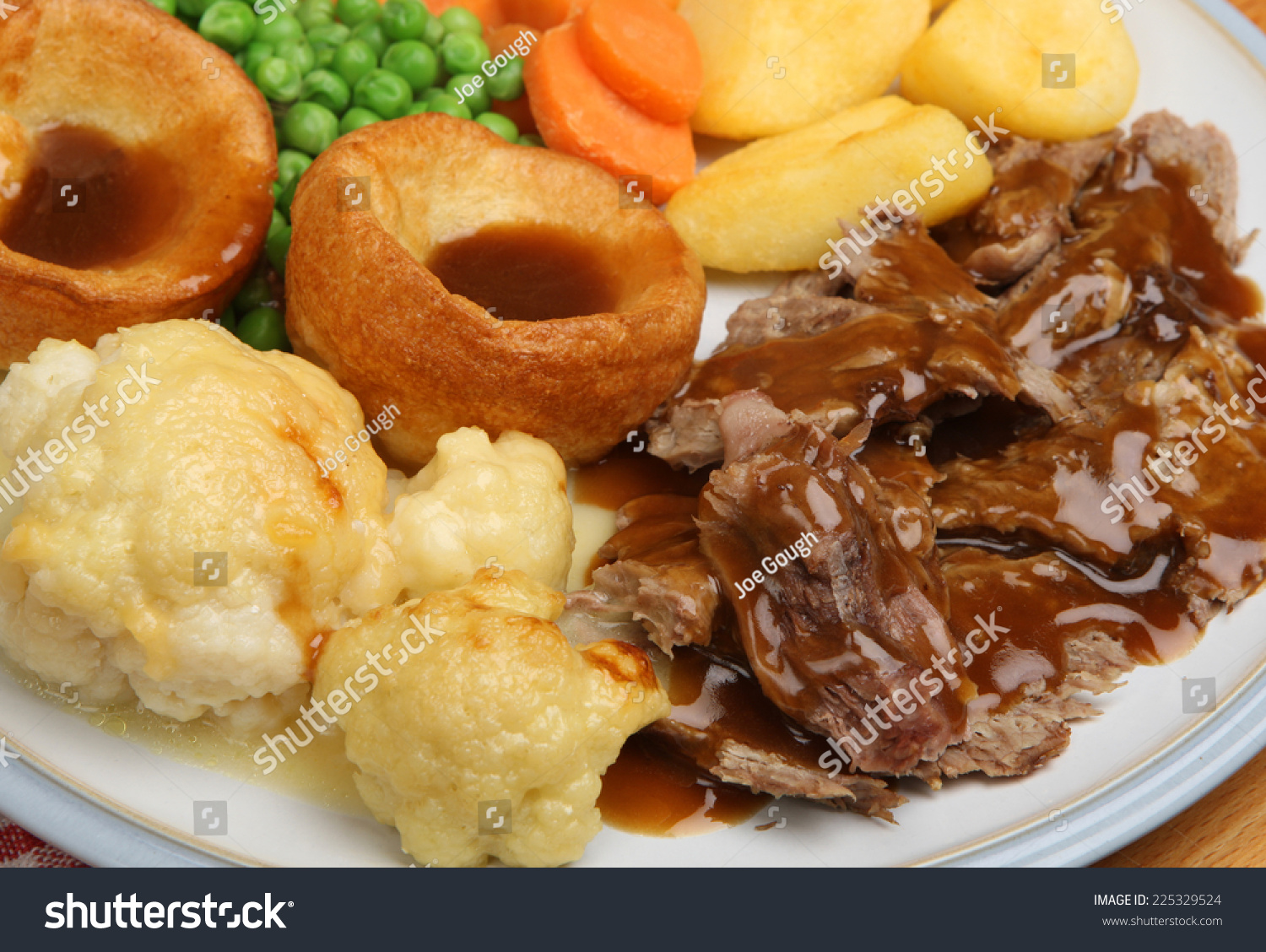 Traditional Sunday Roast Dinner With Yorkshire Puddings And Gravy ...