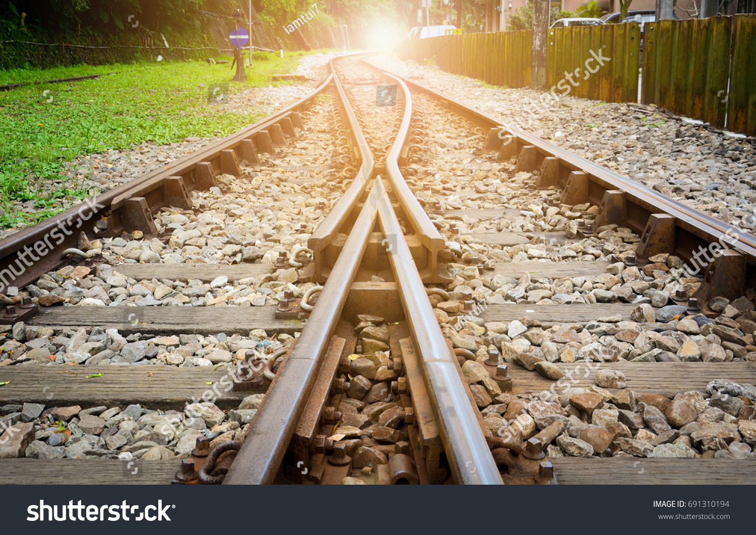 砂利の上の線路 2本の鉄道線路が日没の背景と合流 成功のコンセプト の写真素材 今すぐ編集