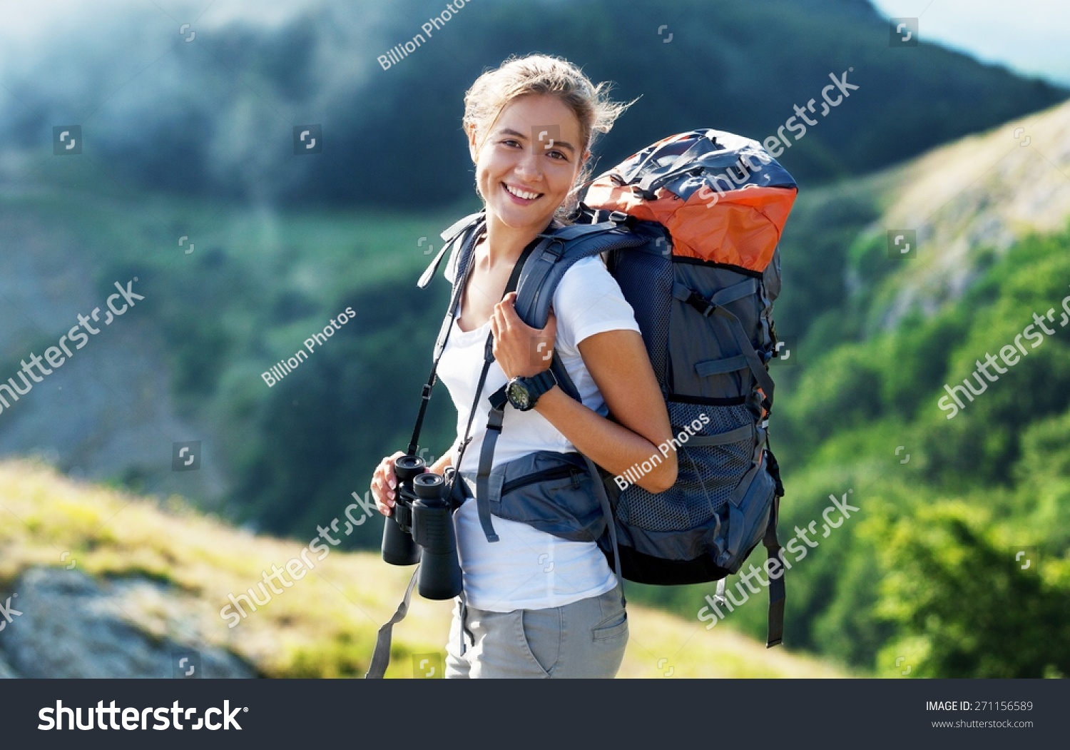 Woman traveler with backpack hiking in mountains Stock Photo by