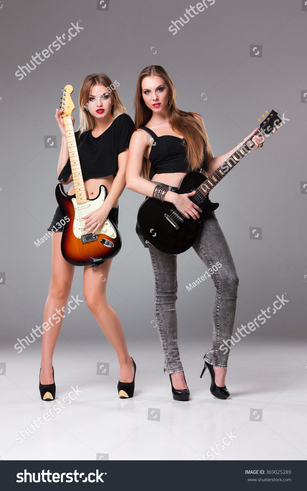 Two Beautiful Girls With Long Hair Playing Guitars In Rock Style On A Gray Background Stock 5441