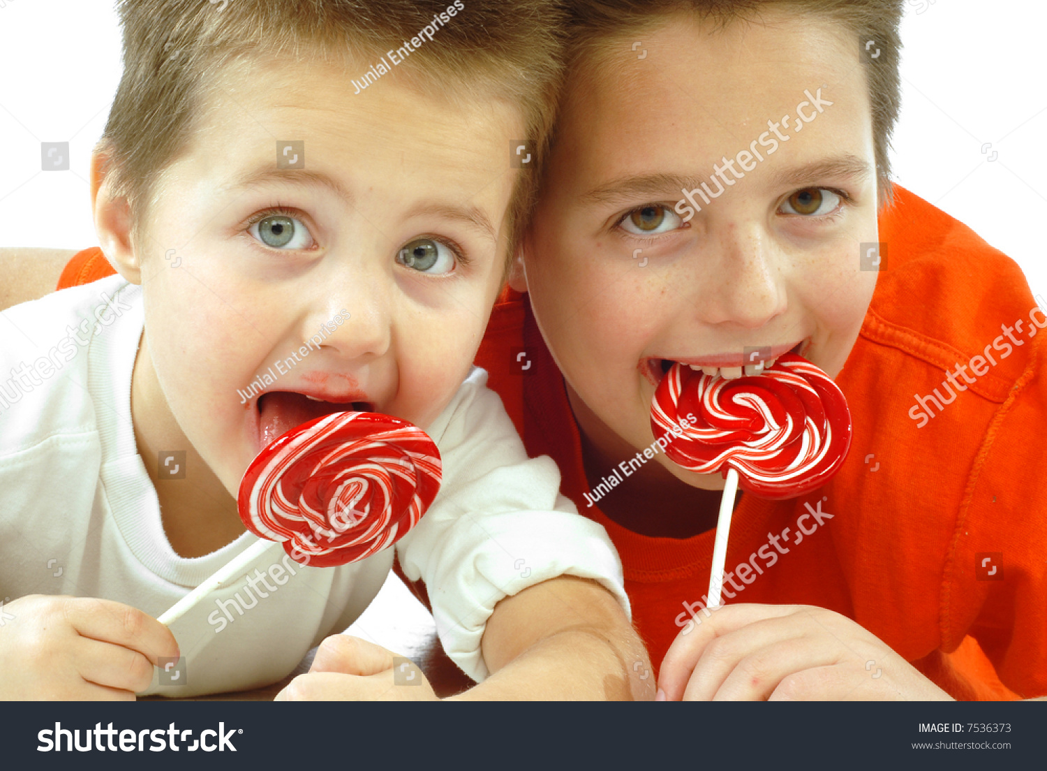 Two Cute Little Brothers Enjoying Candy Together; Isolated On White ...