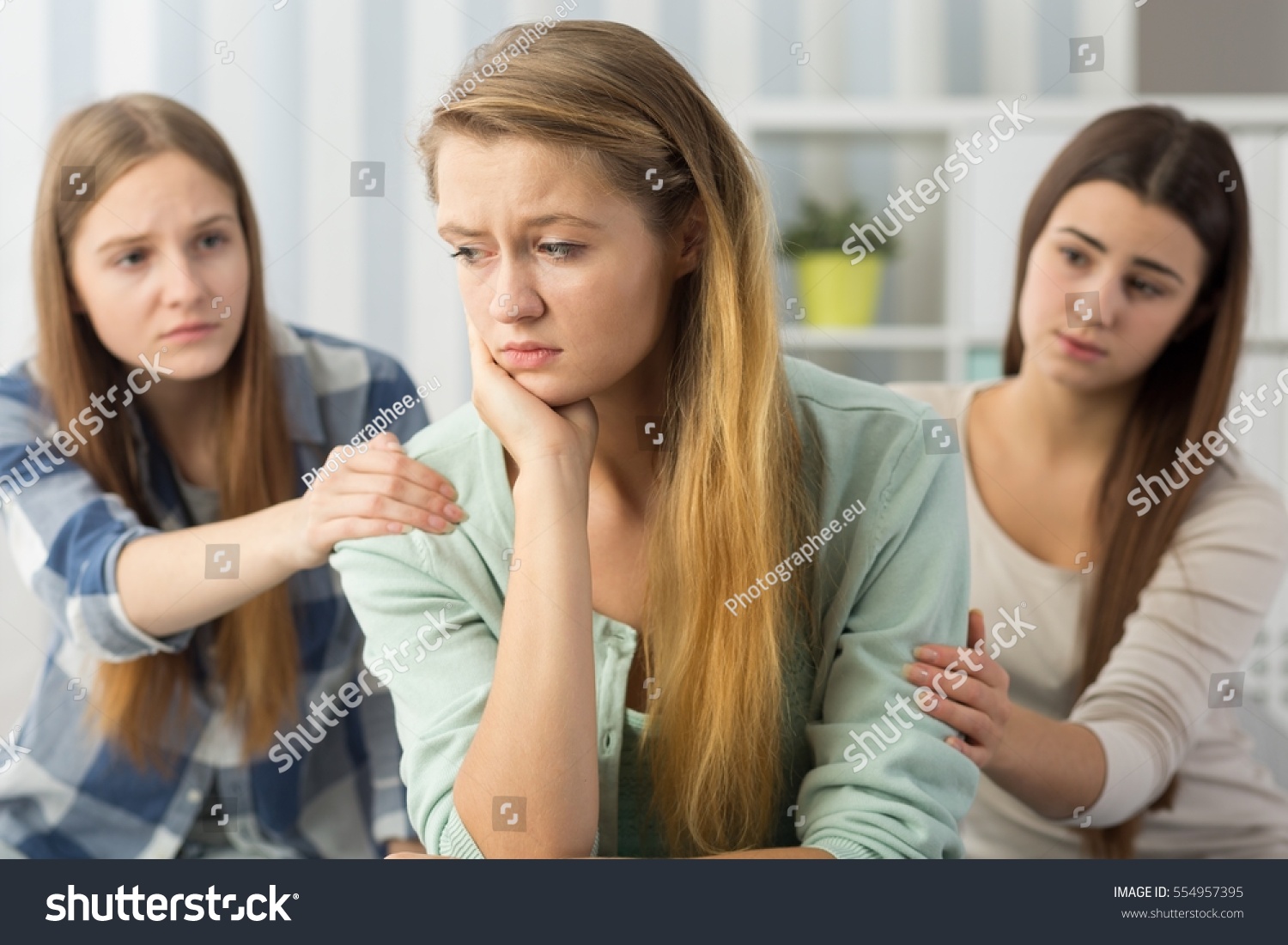 Two Friends Comforting Sorrowful Young Female Stock Photo 554957395