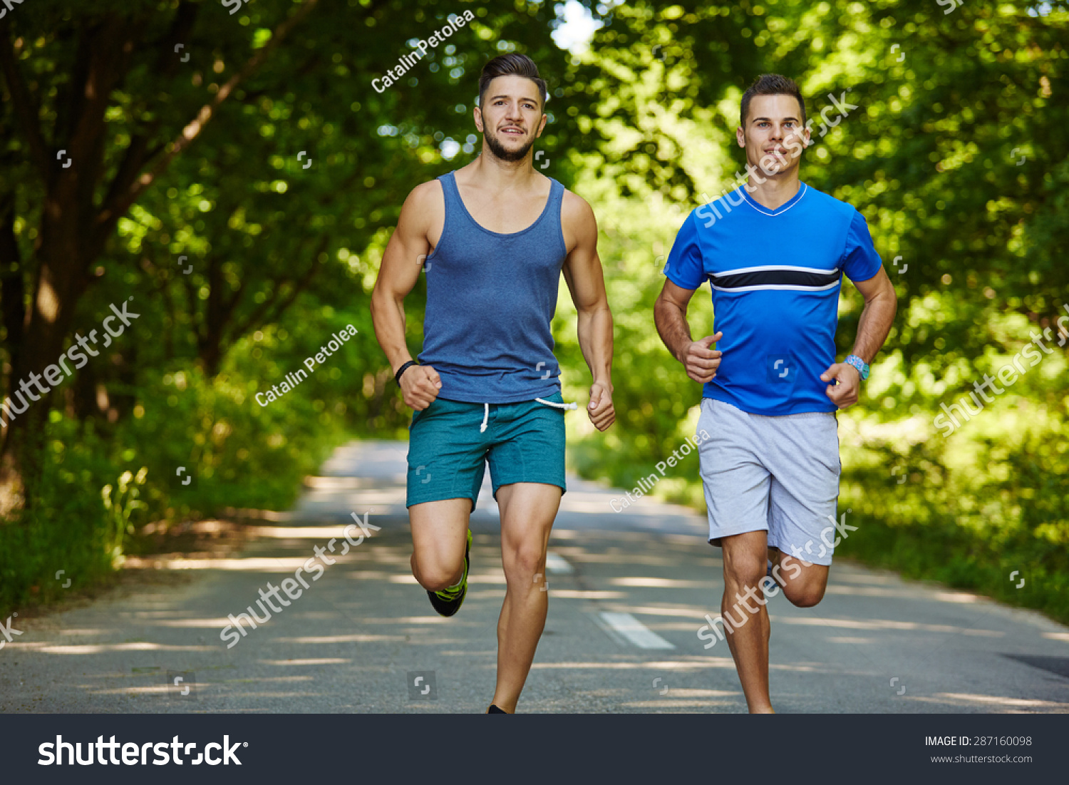 Two Friends Running Through The Forest On A Jogging Trail Stock Photo ...