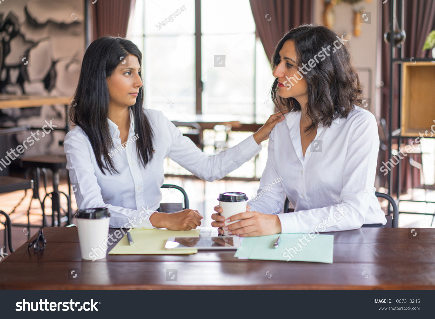 Two Serious Business Women Talking Cafe Stock Photo 1067313245