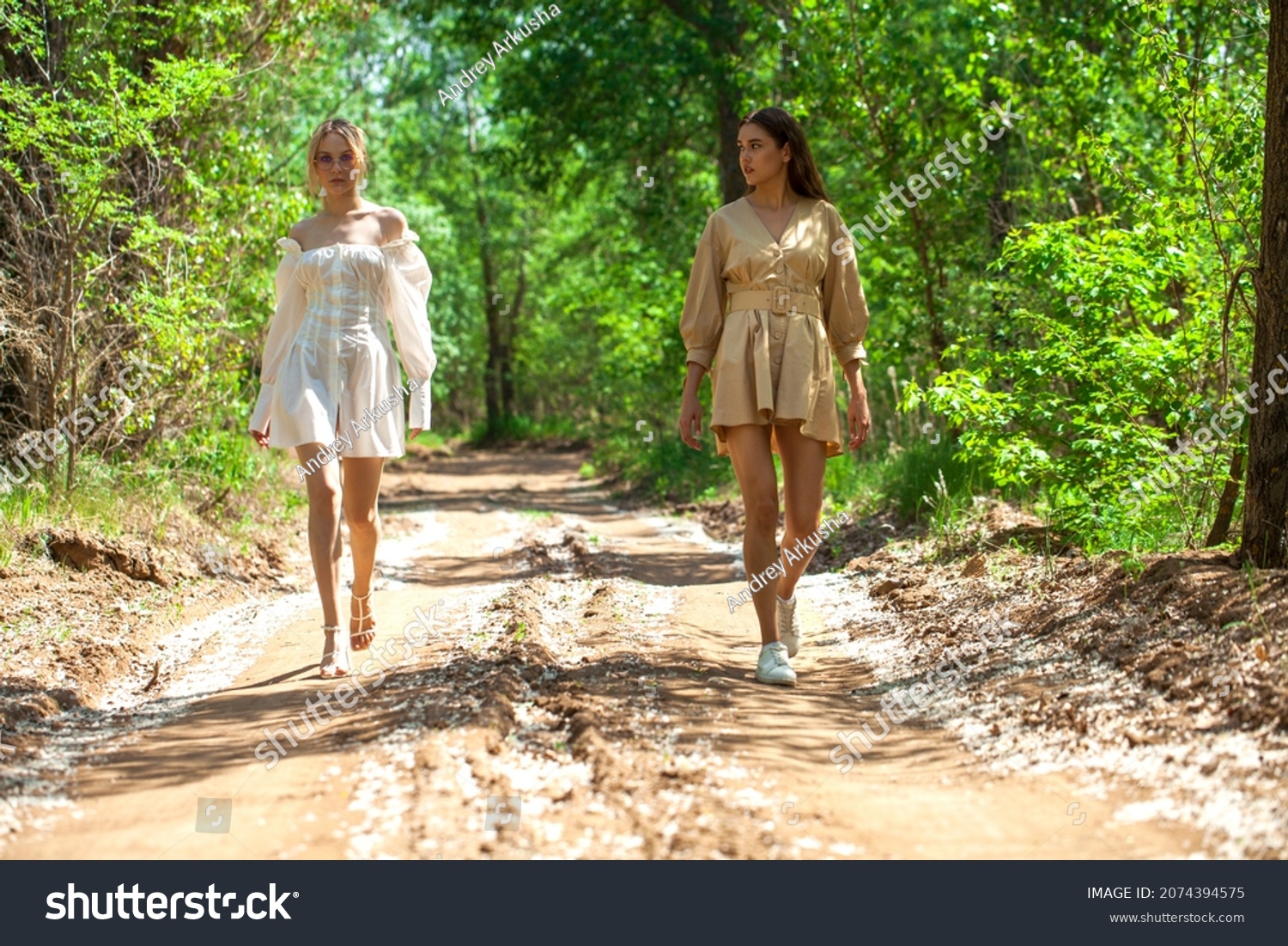 Two chicks in pretty summer outfits walk across the street
