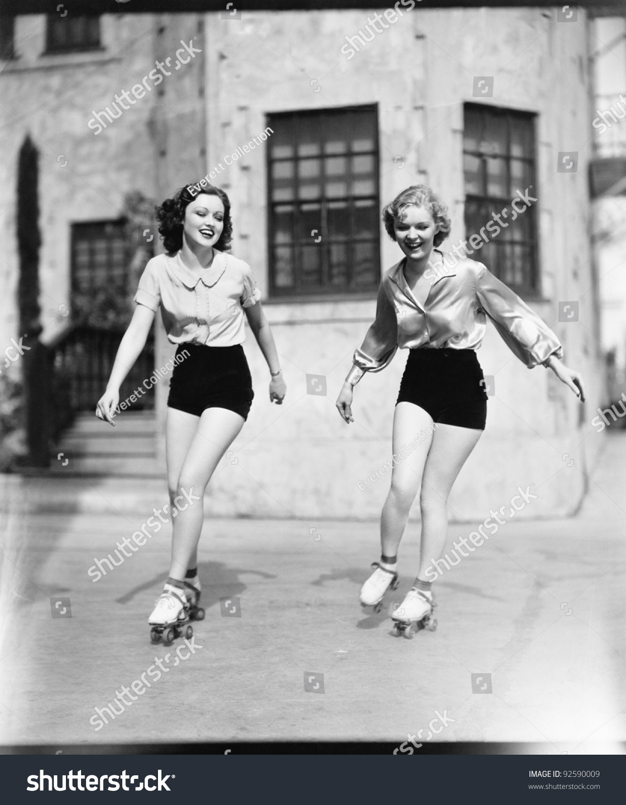 Two Young Women Roller Skating On The Road And Smiling Stock Photo ...