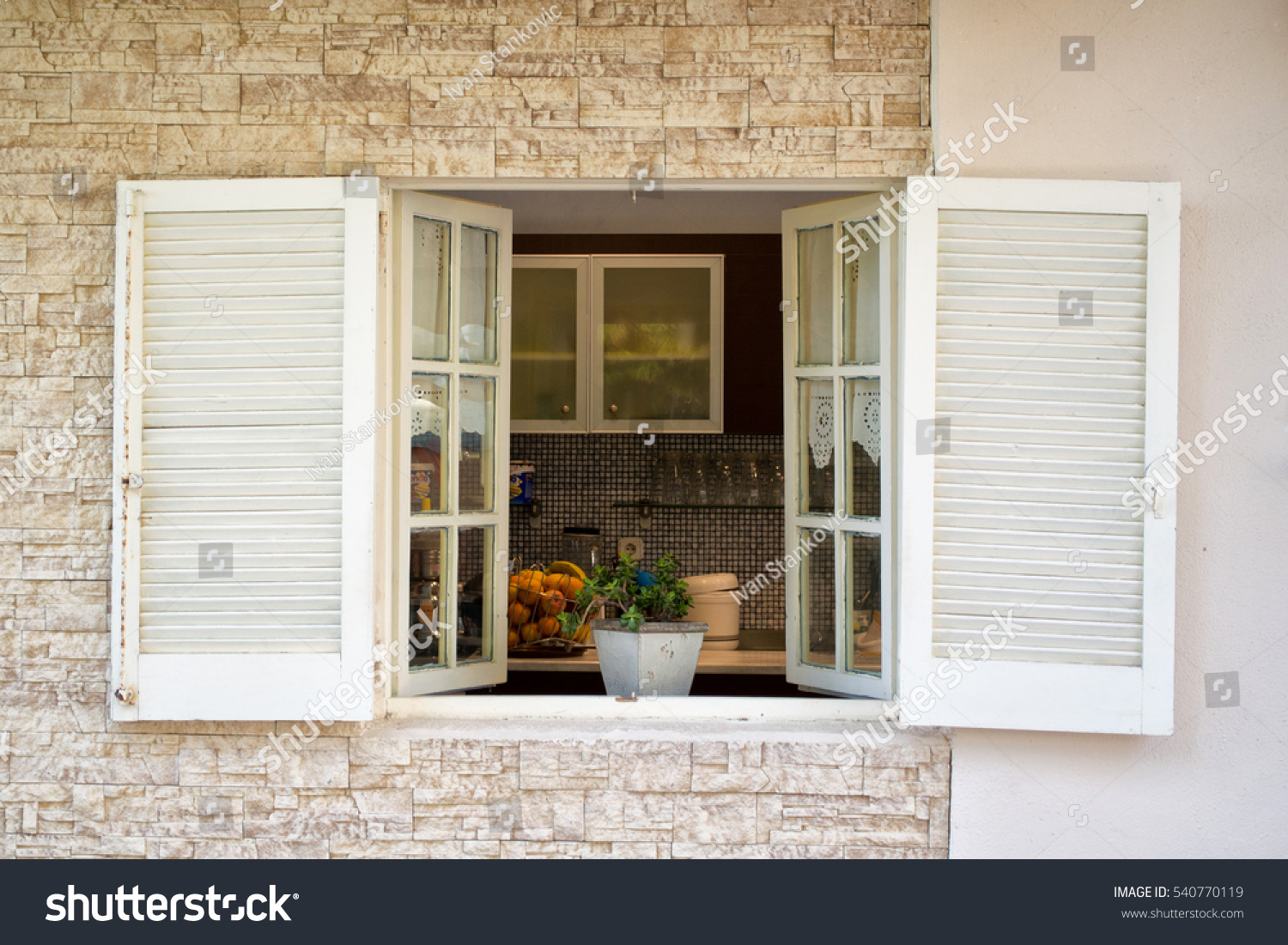 view into kitchen through white wooden stock photo view into kitchen through white wooden stock photo