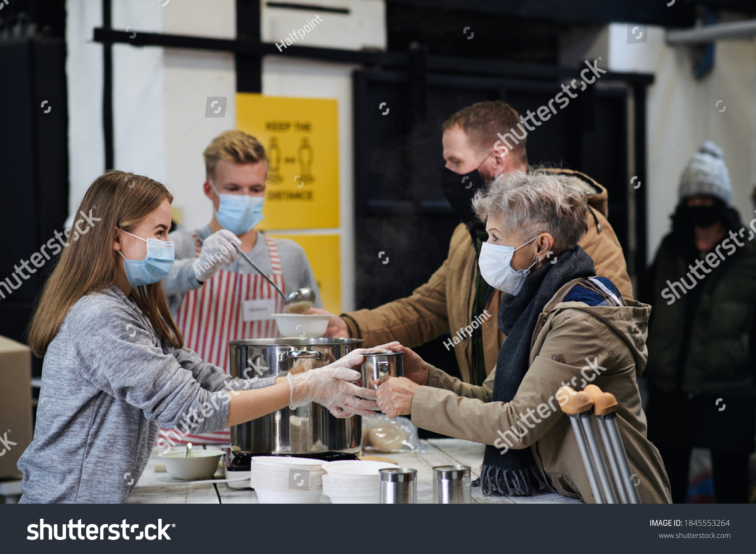 Stock Photo Volunteers Serving Hot Soup For Homeless In Community Charity Donation Center Coronavirus Concept 1845553264 