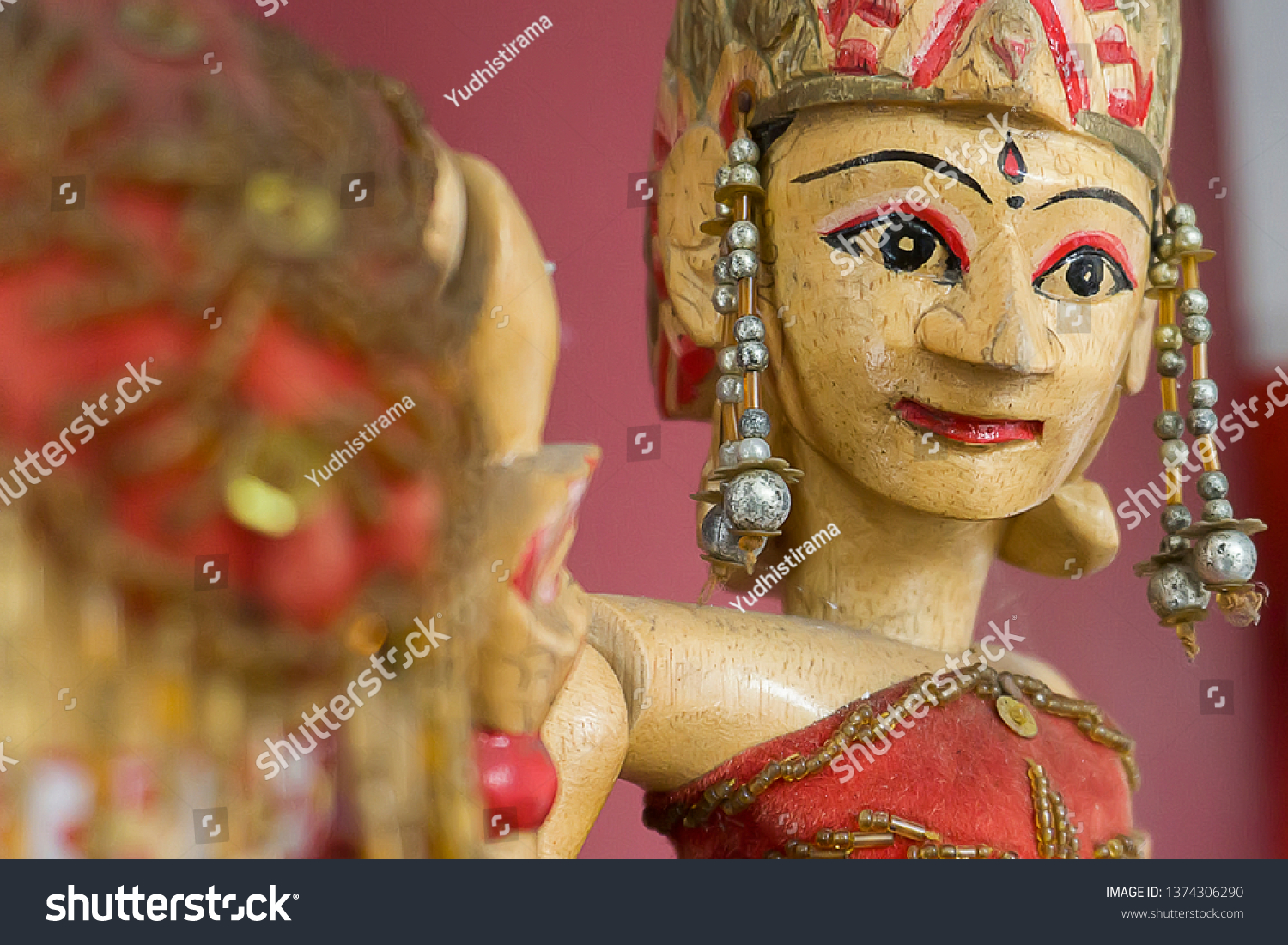  A close up of a wooden Wayang Golek puppet, a traditional Indonesian puppet made of wood and fabric.