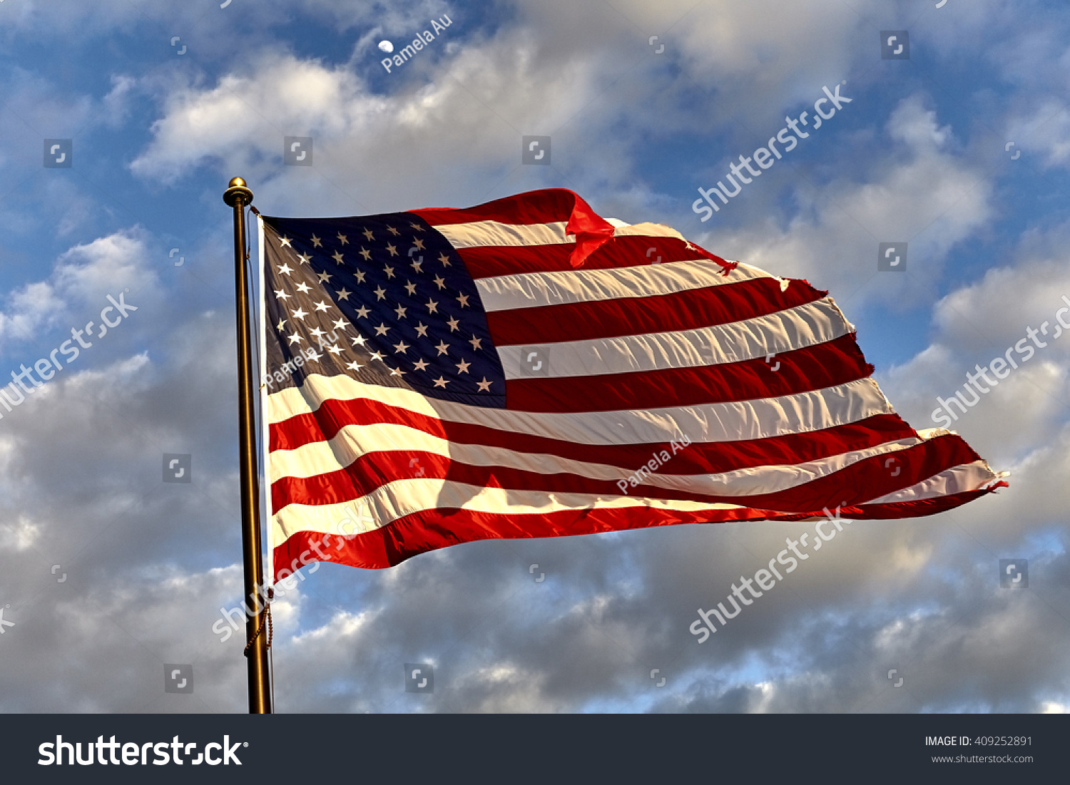 Weathered American Flag On Flagpole Waving In The Wind Against Clouds ...