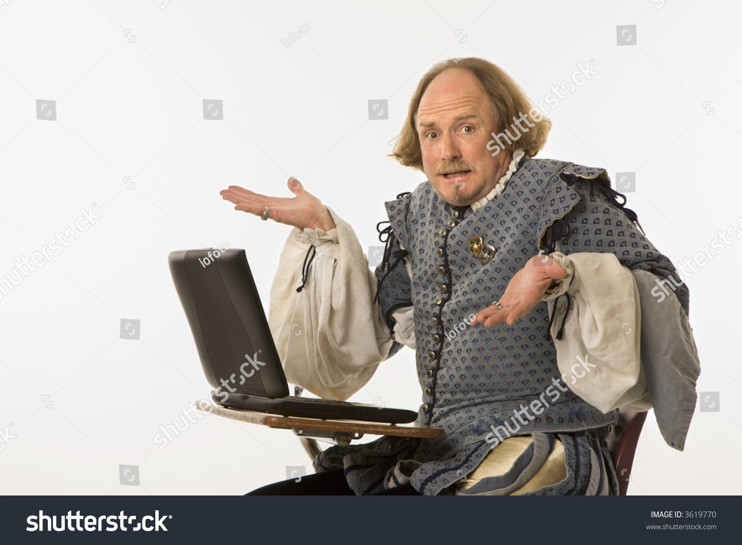 stock-photo-william-shakespeare-in-period-clothing-sitting-in-school-desk-with-laptop-computer-shrugging-at-3619770.jpg