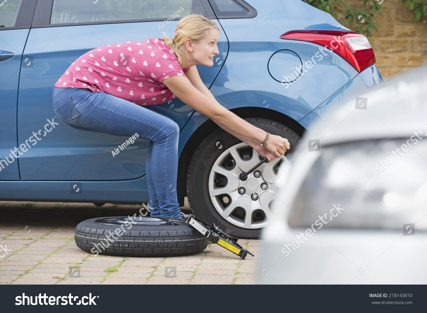 Woman Changing Flat Tire On Car Stock Photo (Edit Now) 218143810