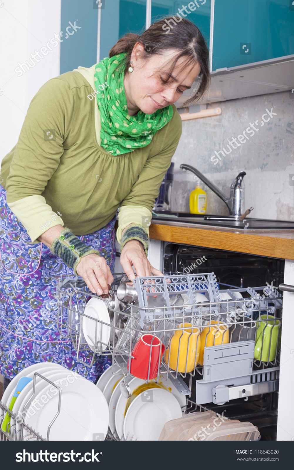 Woman Doing Housework And Putting Dishes In The Dishwasher Woman Doing Housework And Putting Dishes In The Dishwasher