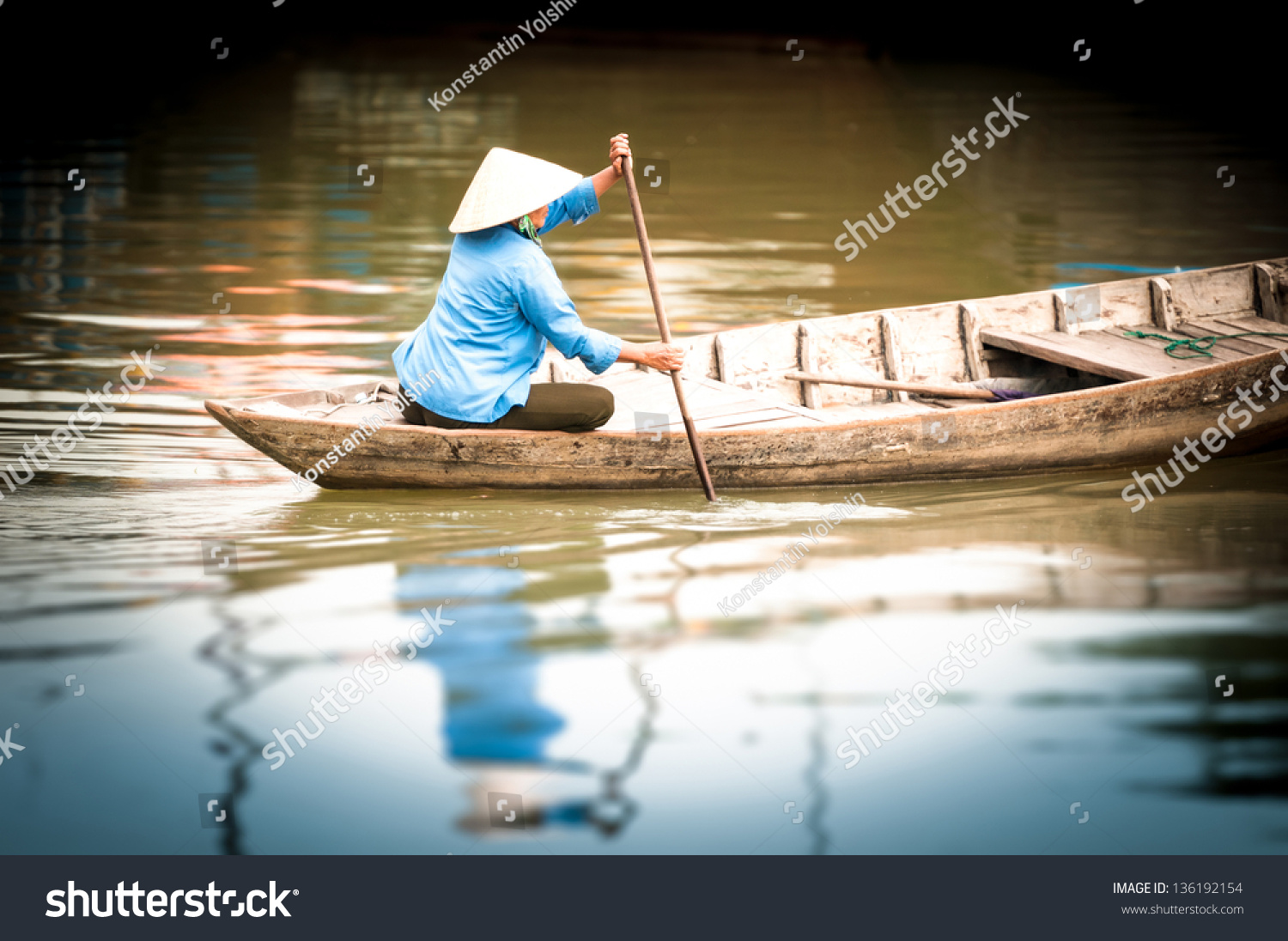 Woman In Conical Hat Sitting On Canoe And Rowing. Traditional Asian ...