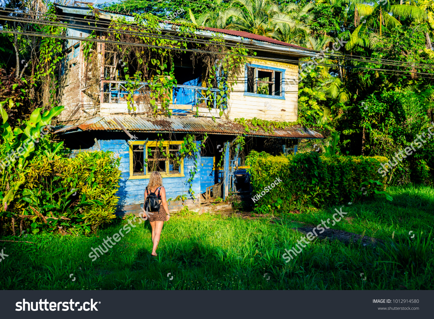 stock-photo-woman-in-front-of-abandoned-house-in-cahuita-puerto-limon-costa-rica-1012914580.jpg