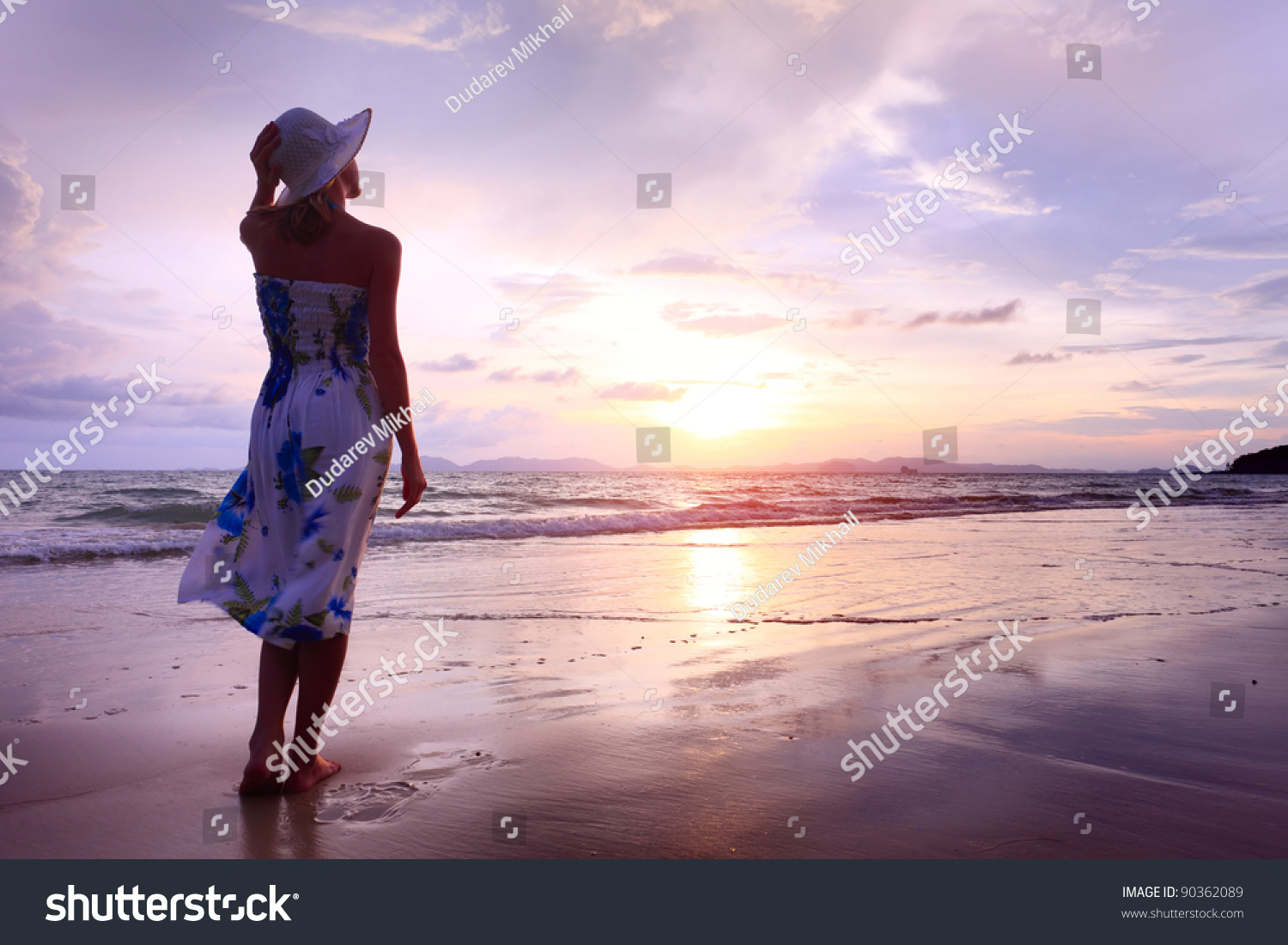 Woman In Summer Dress Standing On A Sandy Beach And Looking To The ...