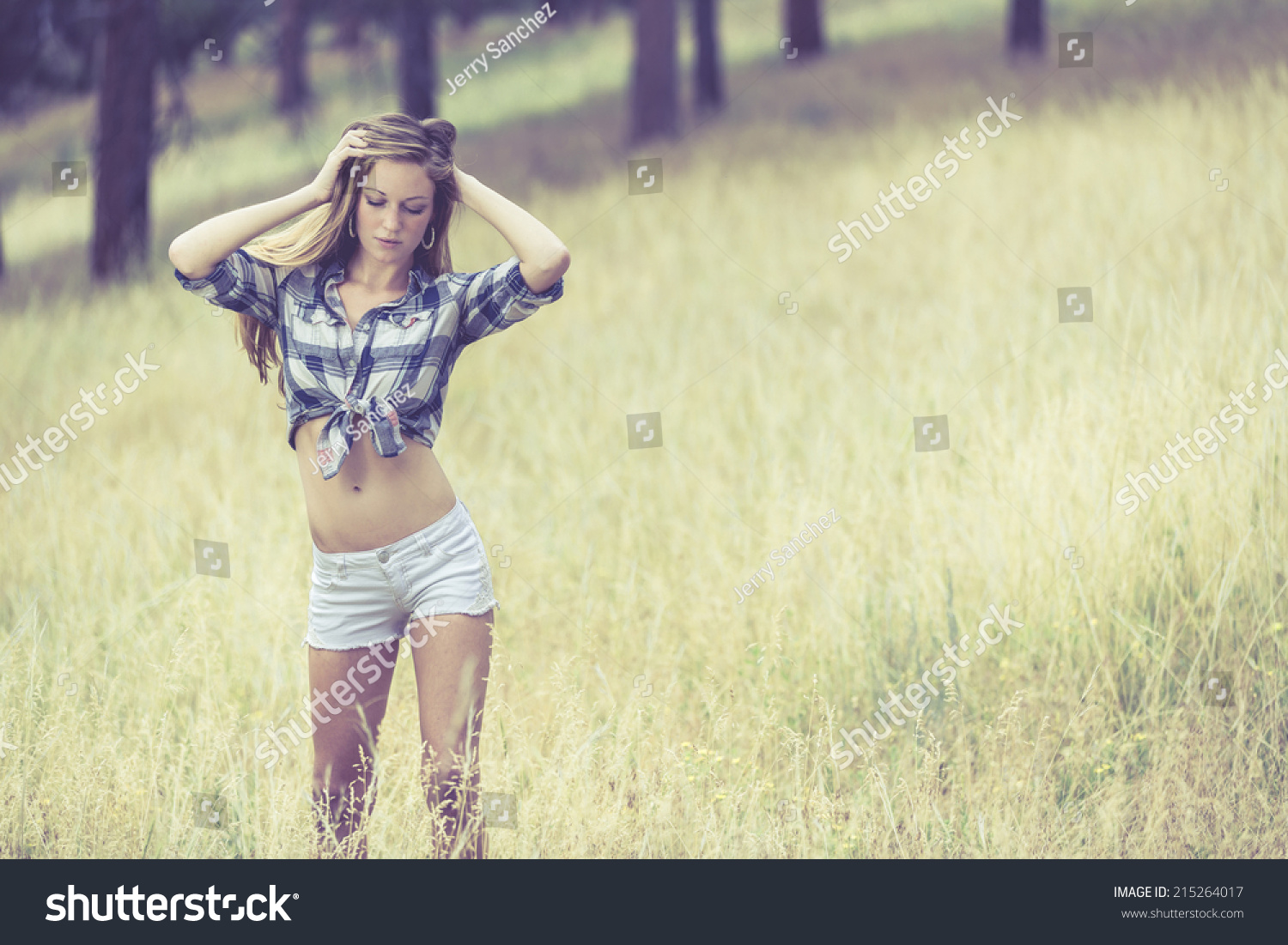 Woman In Tight White Jeans Shorts And Tied Up Blue Flannel Shirt Posing ...
