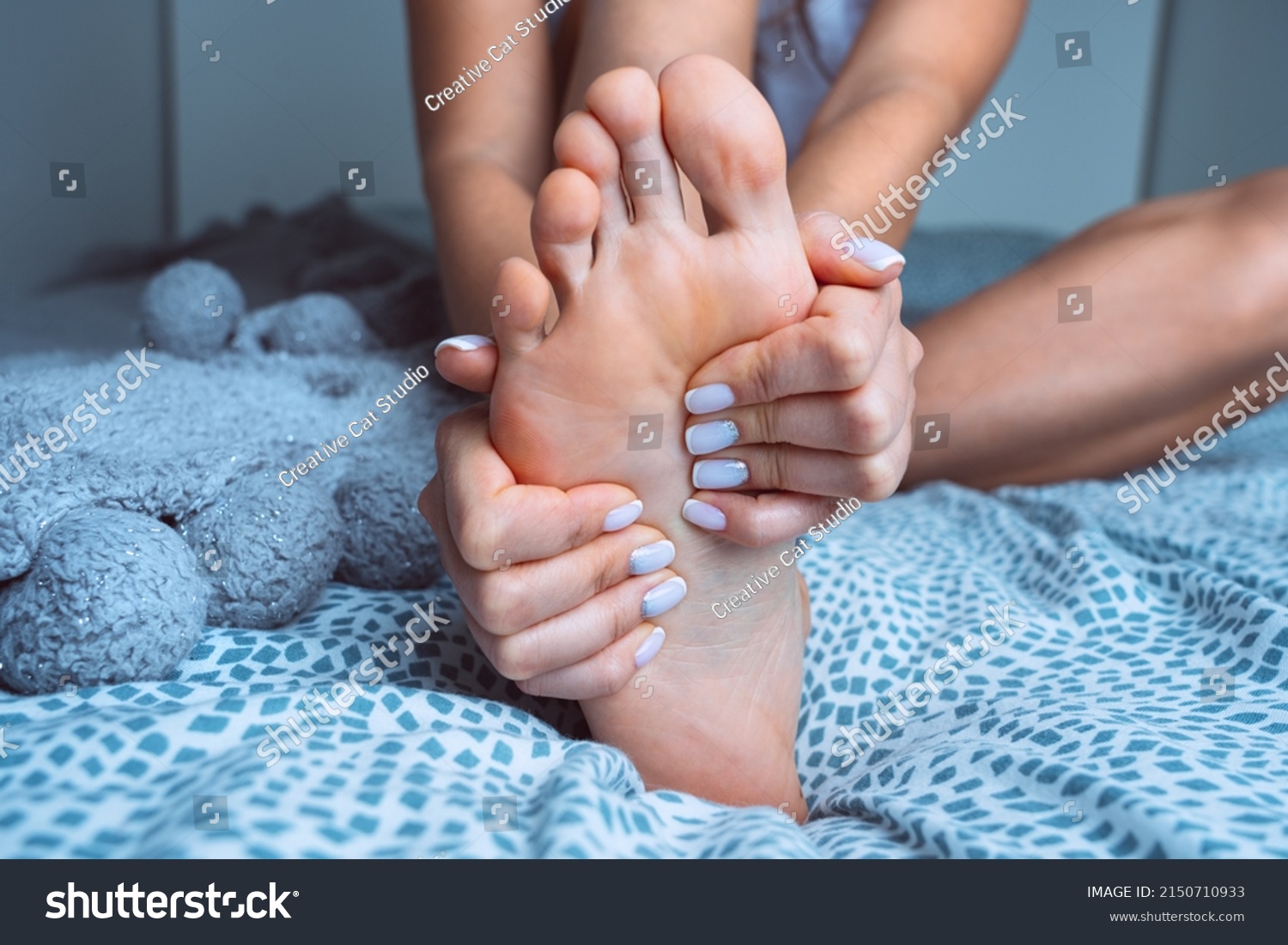 woman-massaging-tired-painful-foot-bed-stock-photo-2150710933