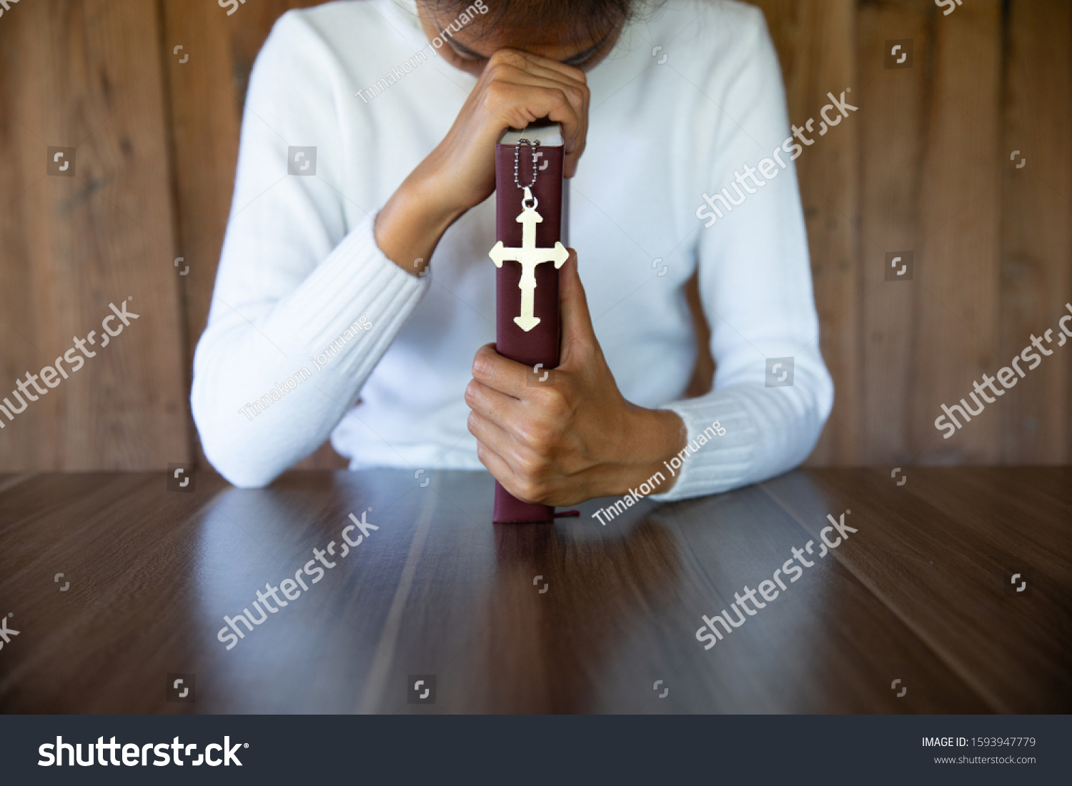 Woman Praying While Holding Bible Cross Stock Photo (Edit Now) 1593947779