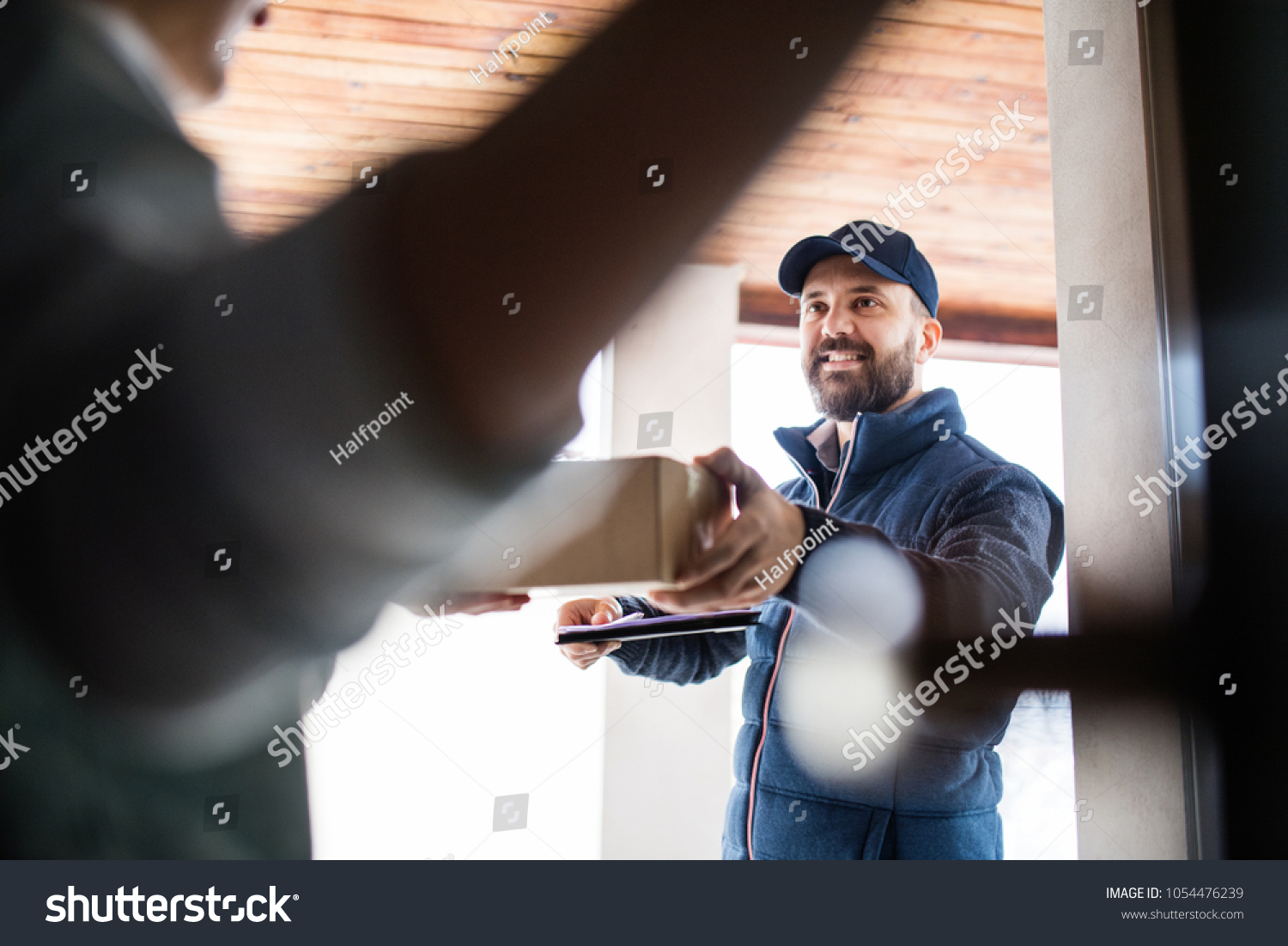 Woman Receiving Parcel Delivery Man Door Stock Photo 1054476239