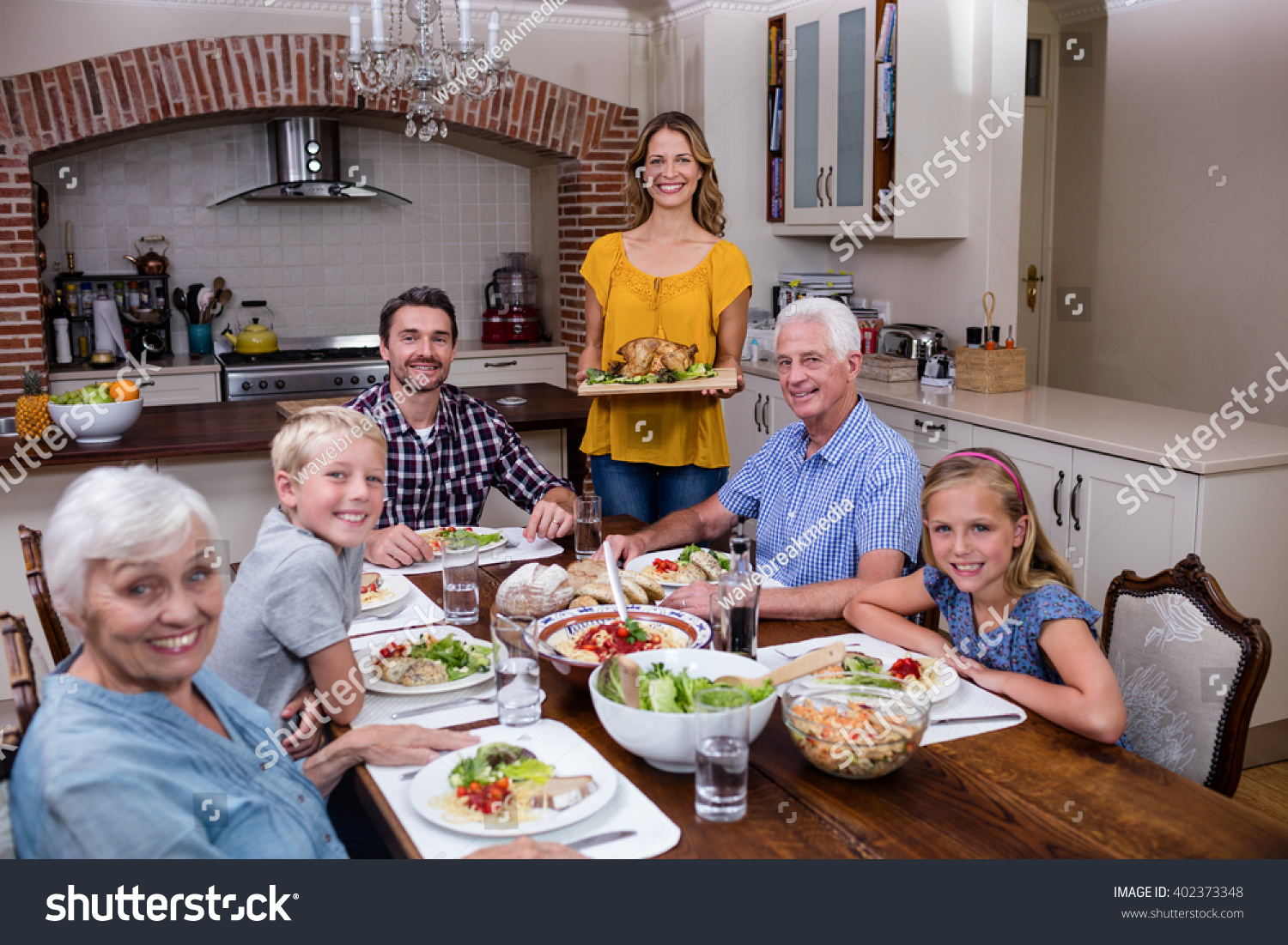 Woman Serving Food Her Family Kitchen Stock Photo (Edit Now) 402373348