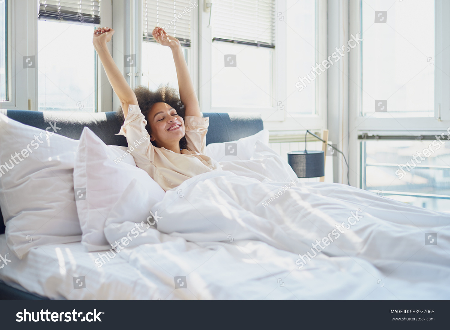 腕を上げてベッドに寝た女性 の写真素材 今すぐ編集