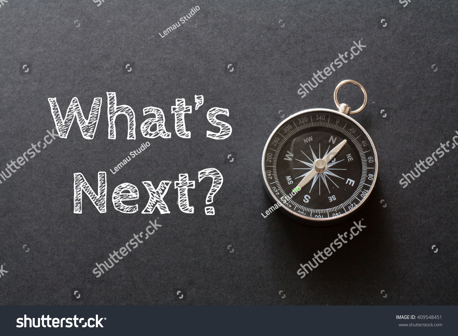 Written What's Next words on black background with compass