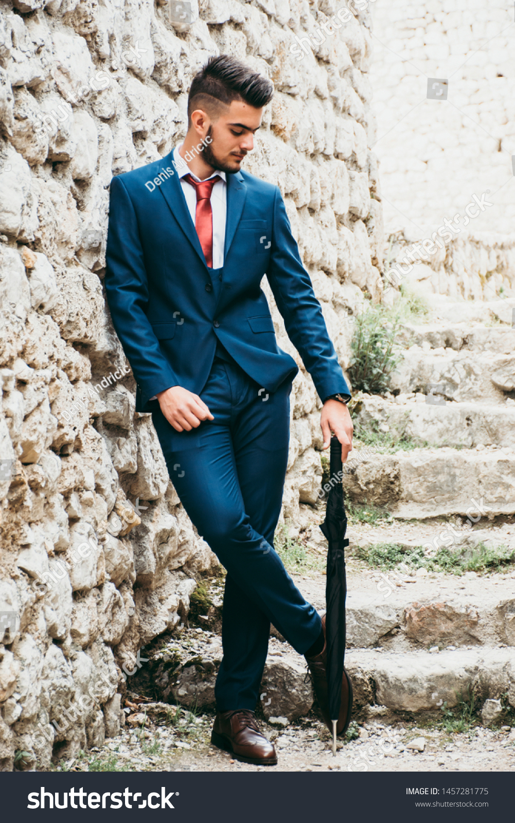 navy blue suit with red tie and brown shoes