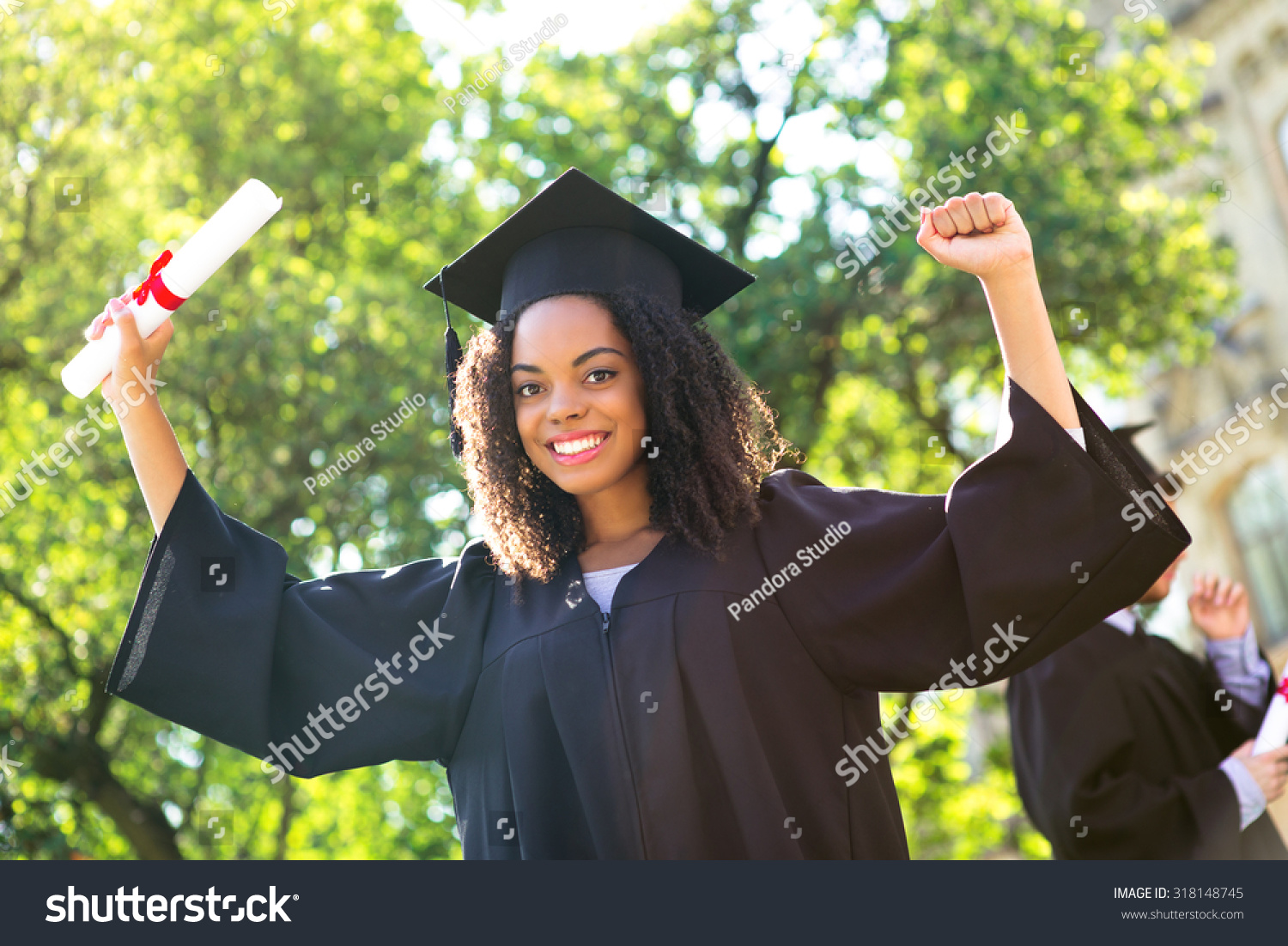 Young Afro American Female Student Dressed In Black Graduation Gown ...